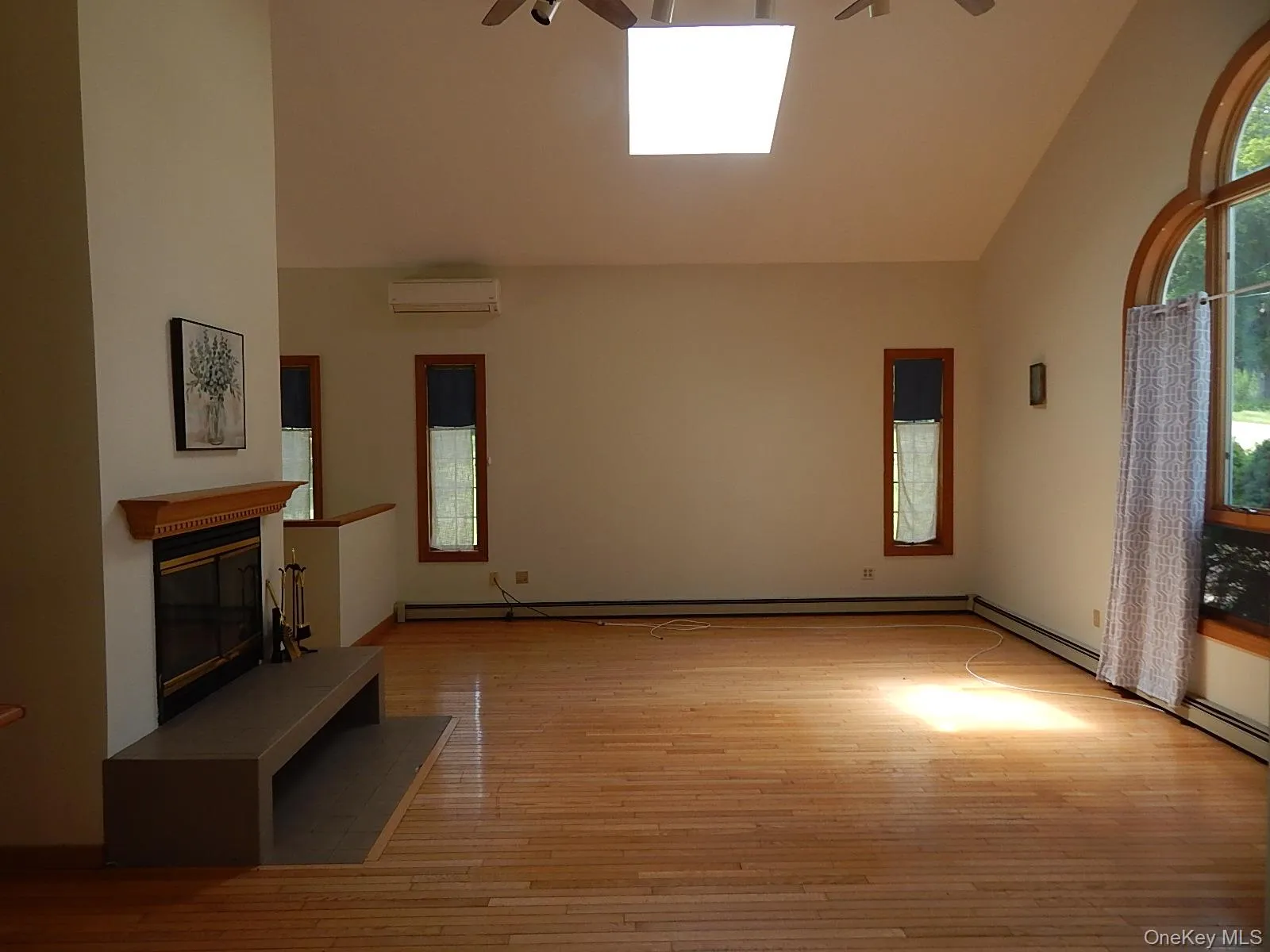 Sunken living room with cathedral ceilings, skylight, paddle fans, finished oak flooring, and raised hearth fireplace. Sunken living room with cathedral ceilings, skylight, paddle fans, finished oak flooring, and raised hearth fireplace.