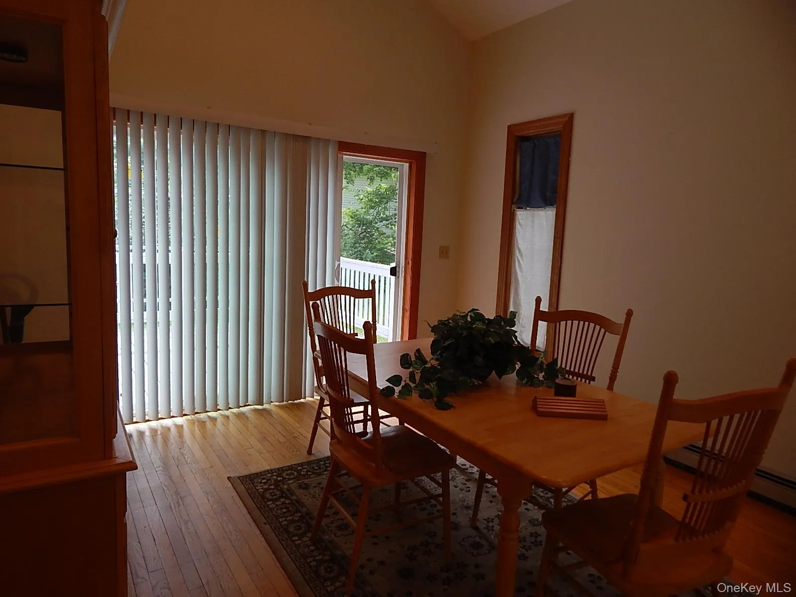 Dining room with cathedral ceiling and sliding glass door opening to deck. Dining room with cathedral ceiling and sliding glass door opening to deck.