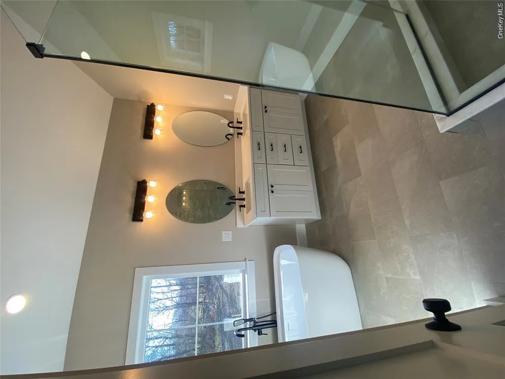 Conveniently located this stylish lower-level master bath features a walk-in shower, custom vanity, contemporary fixtures, and striking designer finishes, providing comfort and flexibility. Conveniently located this stylish lower-level master bath features a walk-in shower, custom vanity, contemporary fixtures, and striking designer finishes, providing comfort and flexibility.