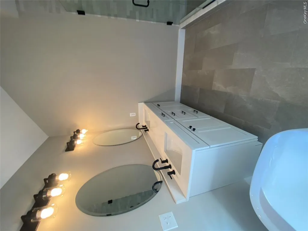 The custom vanity is accented by designer lighting, contemporary fixtures, and sophisticated finishes that elevate the space with timeless style. The custom vanity is accented by designer lighting, contemporary fixtures, and sophisticated finishes that elevate the space with timeless style.