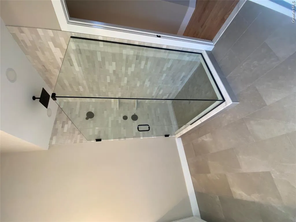 Floor-to-ceiling tile and a sleek glass enclosure transform the walk-in shower into a luxurious spa-like retreat. Floor-to-ceiling tile and a sleek glass enclosure transform the walk-in shower into a luxurious spa-like retreat.