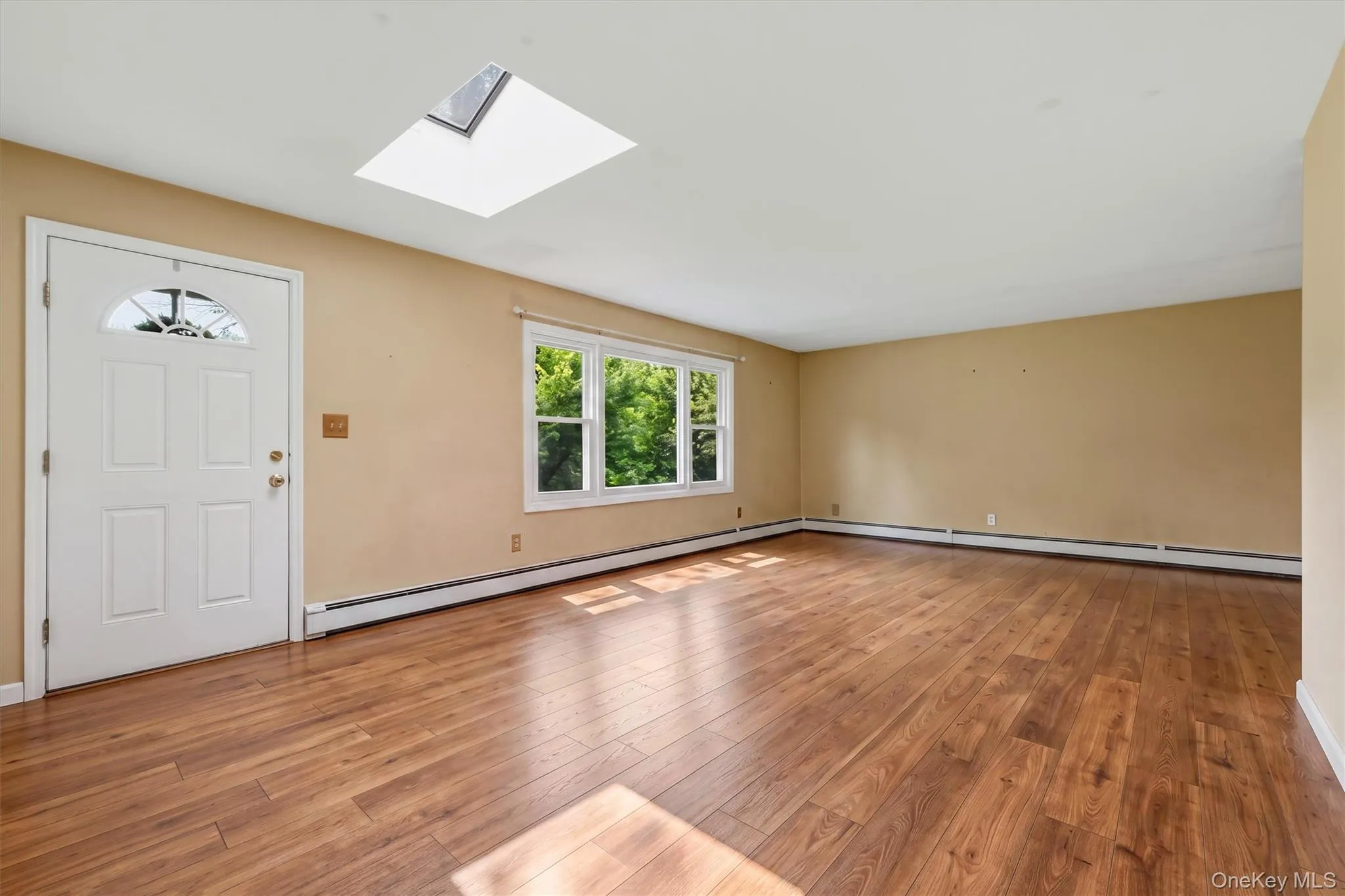 Spacious living room has skylight and large sunny front window (VIRTUALLY STAGED) Spacious living room has skylight and large sunny front window (VIRTUALLY STAGED)