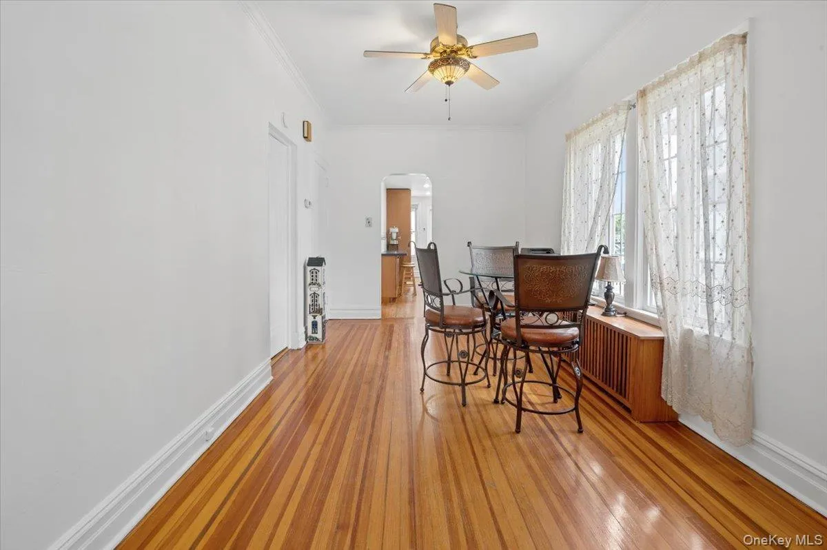 Hardwood flooring throughout, crown molding, and a ceiling fan with integrated lighting Hardwood flooring throughout, crown molding, and a ceiling fan with integrated lighting