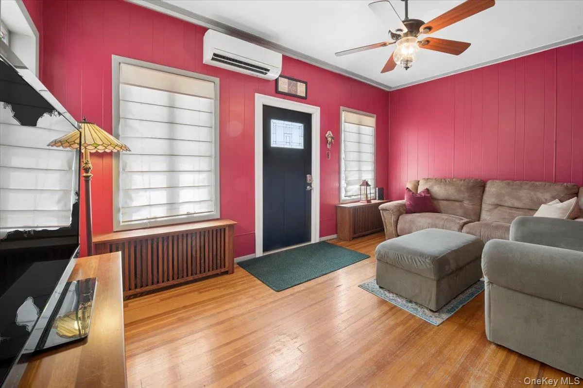 Hardwood flooring throughout, with a dark-paneled front door featuring decorative glass leading to the living room. Hardwood flooring throughout, with a dark-paneled front door featuring decorative glass leading to the living room.