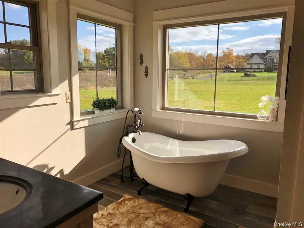 A freestanding soaking tub is perfectly positioned to capture peaceful outdoor views creating a relaxing spa inspired retreat. A freestanding soaking tub is perfectly positioned to capture peaceful outdoor views creating a relaxing spa inspired retreat.