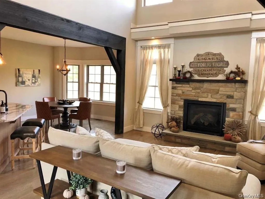The main living area showcases impressive ceiling height, an open layout, and a fireplace centerpiece that adds warmth and character. Thoughtful architectural details and abundant natural light contribute to the room’s spacious and welcoming feel. The main living area showcases impressive ceiling height, an open layout, and a fireplace centerpiece that adds warmth and character. Thoughtful architectural details and abundant natural light contribute to the room’s spacious and welcoming feel.