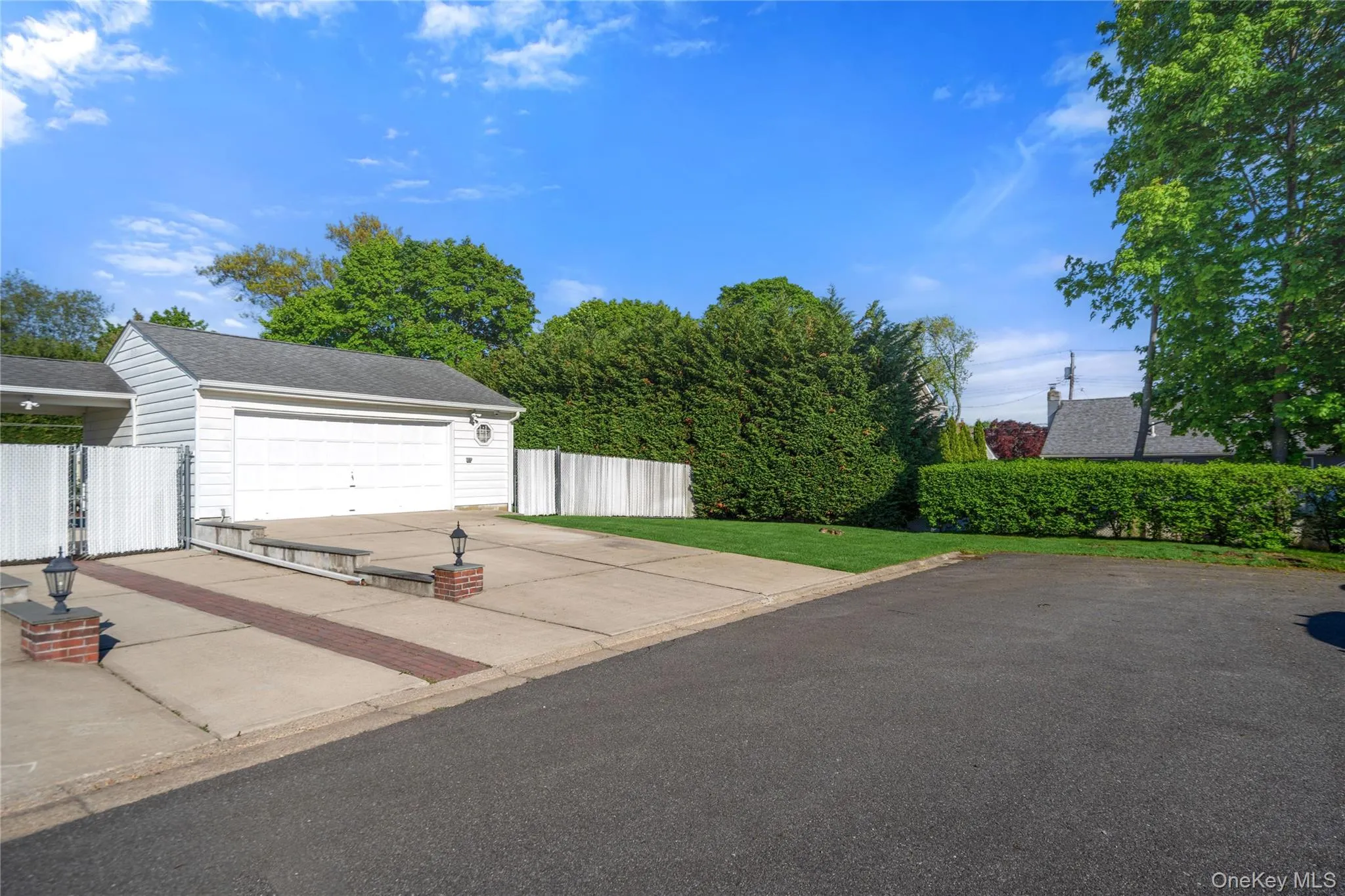 Detached garage structure with a white overhead door and shingle roof Detached garage structure with a white overhead door and shingle roof