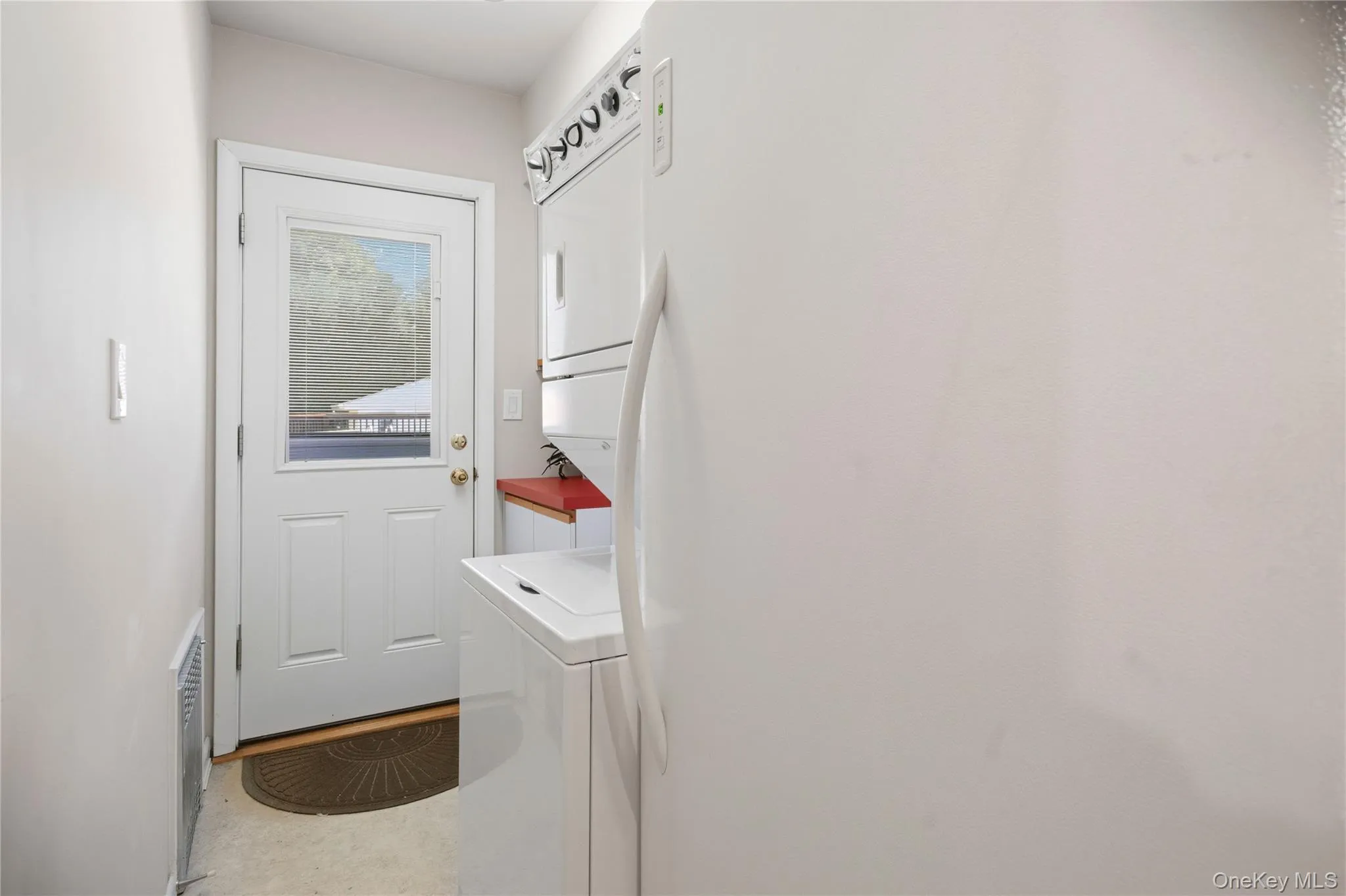 Dedicated laundry area featuring a stacked washer and dryer unit Dedicated laundry area featuring a stacked washer and dryer unit
