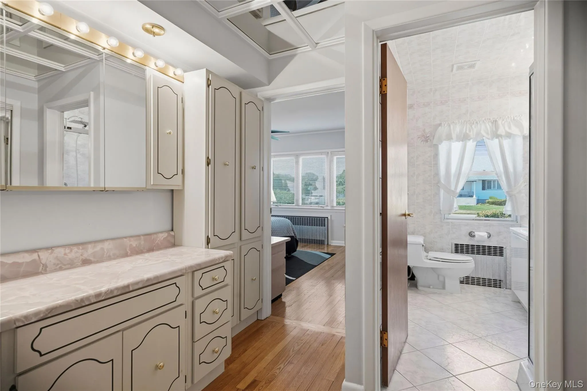 Hallway vanity featuring a light-colored countertop, integrated sink, and ample storage cabinetry Hallway vanity featuring a light-colored countertop, integrated sink, and ample storage cabinetry