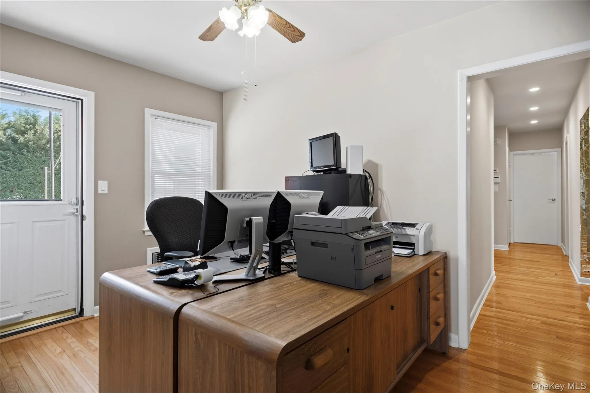 Wood-finish flooring throughout, with a ceiling fan featuring integrated lighting Wood-finish flooring throughout, with a ceiling fan featuring integrated lighting