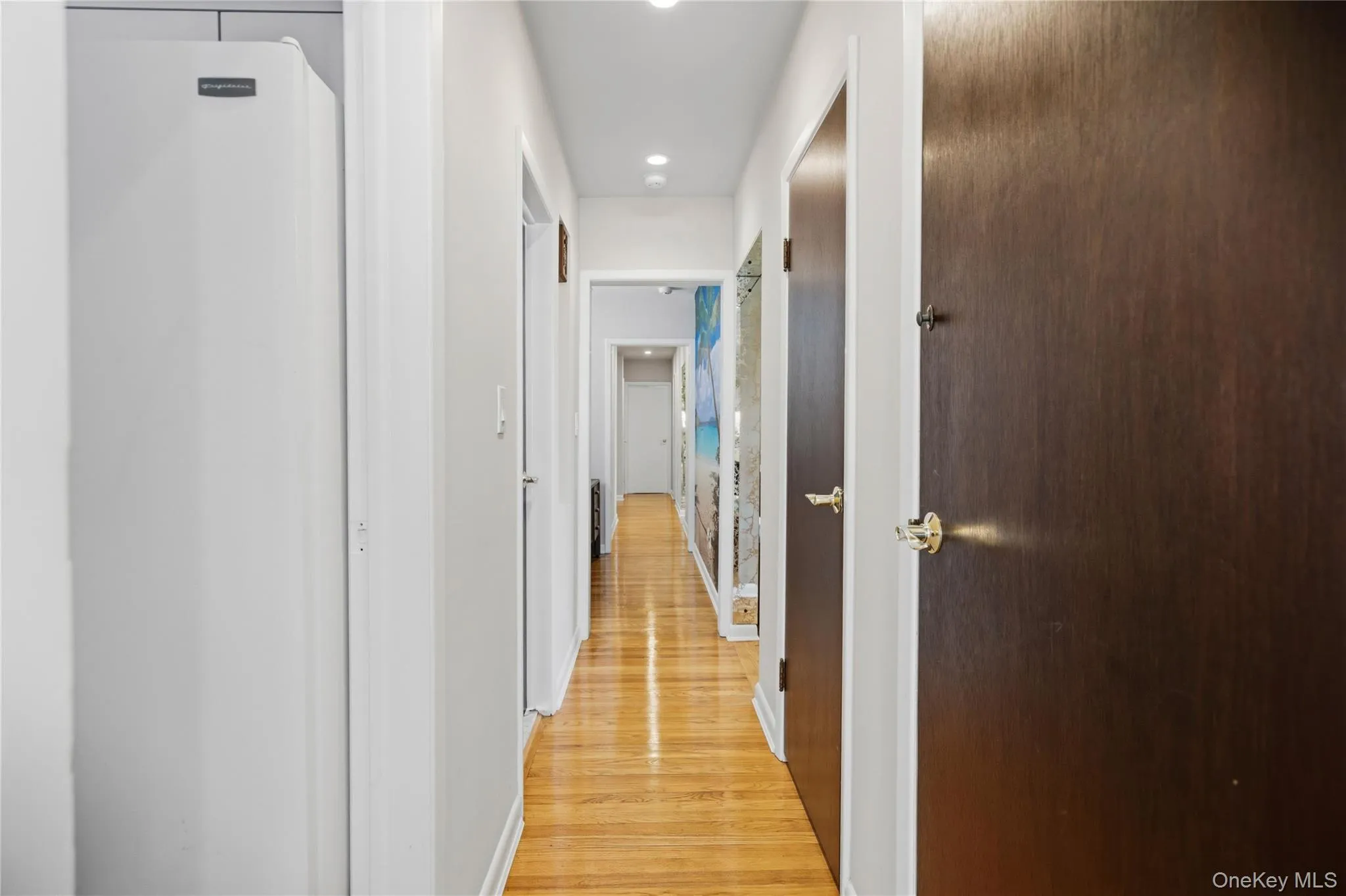 Hardwood flooring extends throughout this hallway with recessed lighting Hardwood flooring extends throughout this hallway with recessed lighting