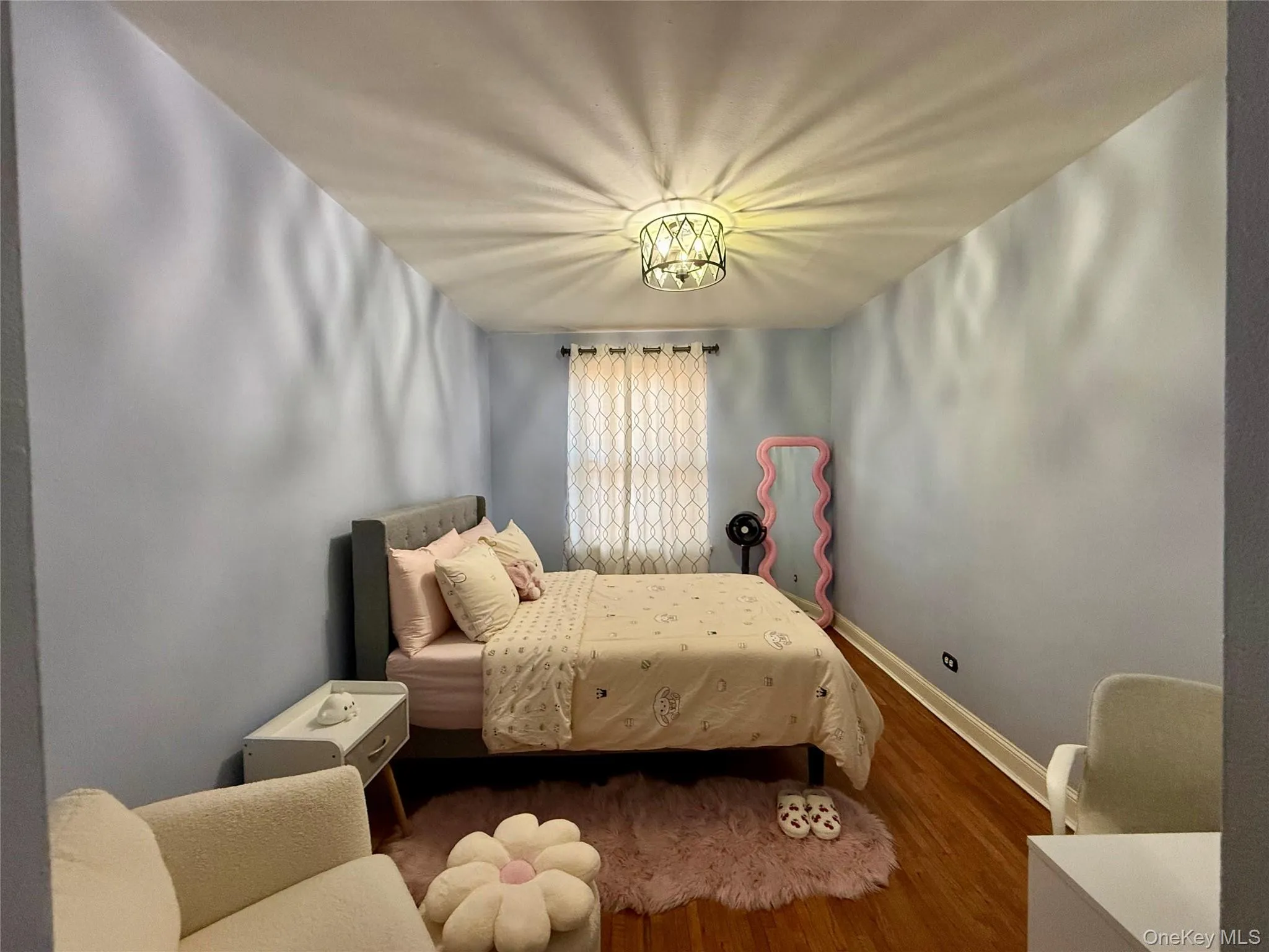 Large window, hardwood flooring, and a contemporary ceiling light fixture Large window, hardwood flooring, and a contemporary ceiling light fixture