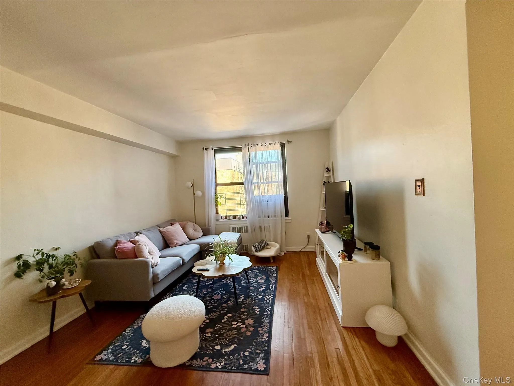 Living space featuring wood flooring and a window with natural light Living space featuring wood flooring and a window with natural light