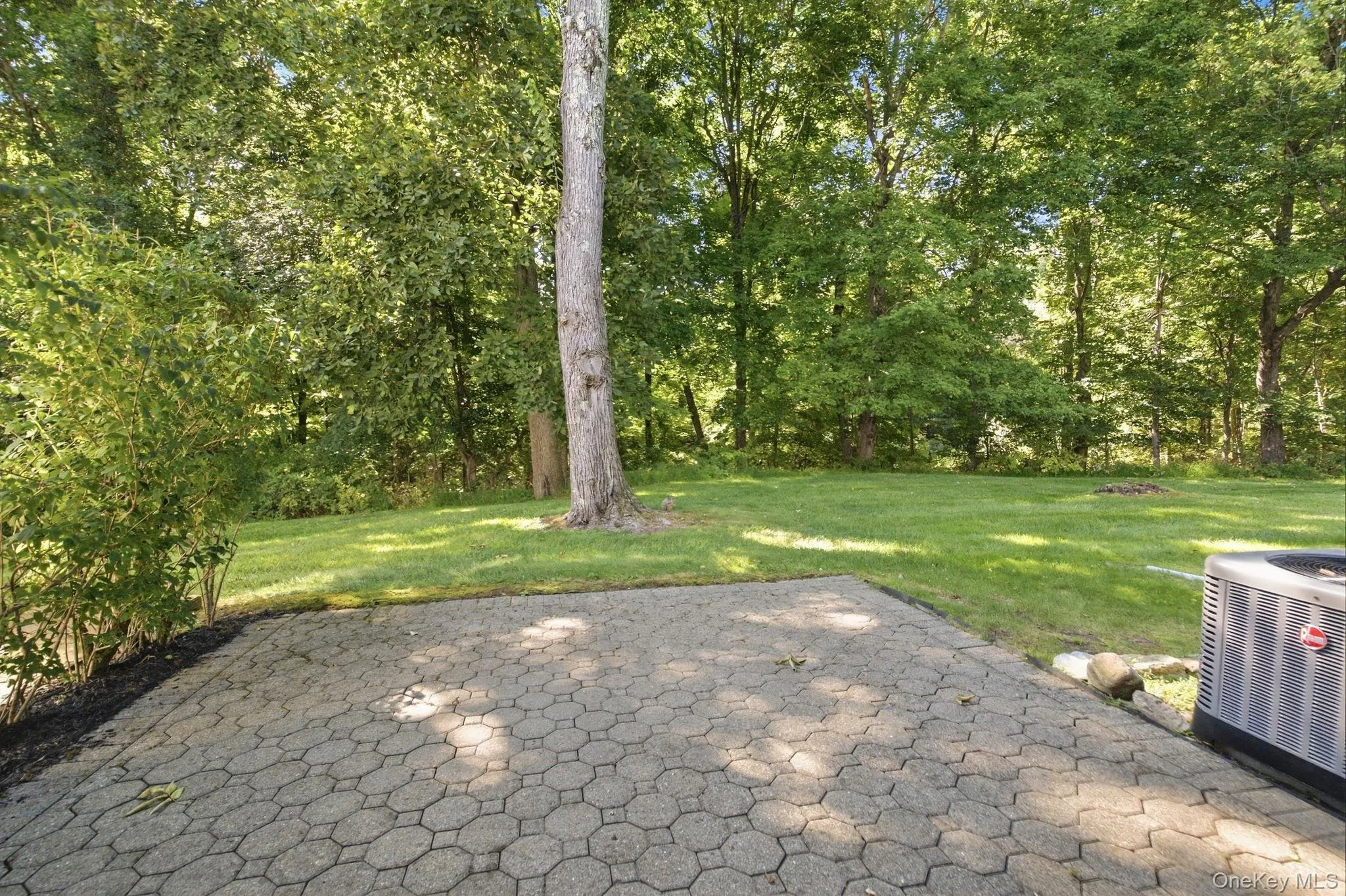 Paver patio extends the living space outdoors to a wooded backyard setting. Paver patio extends the living space outdoors to a wooded backyard setting.