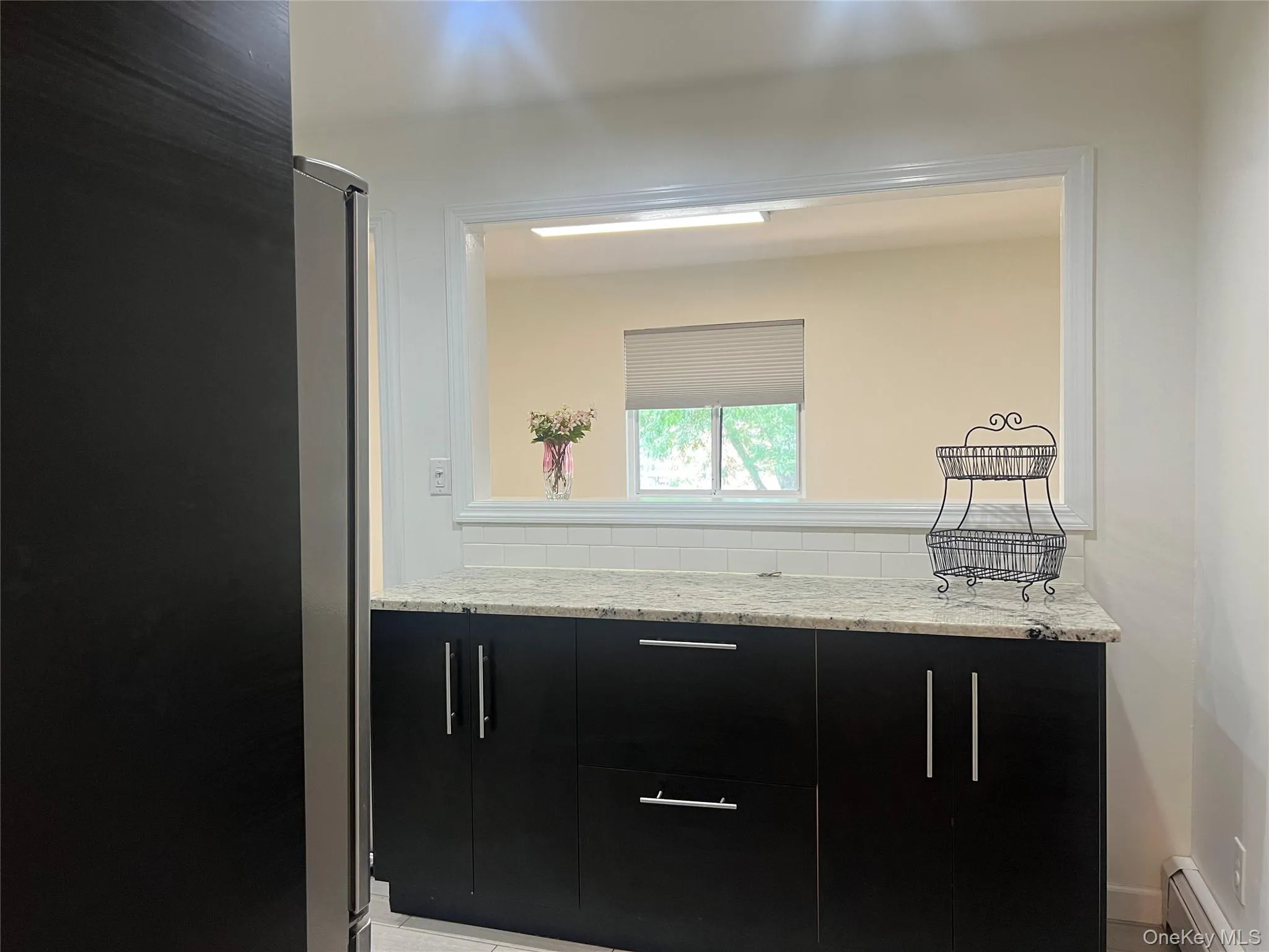Contemporary kitchen featuring dark cabinetry, speckled countertops, and recessed lighting Contemporary kitchen featuring dark cabinetry, speckled countertops, and recessed lighting