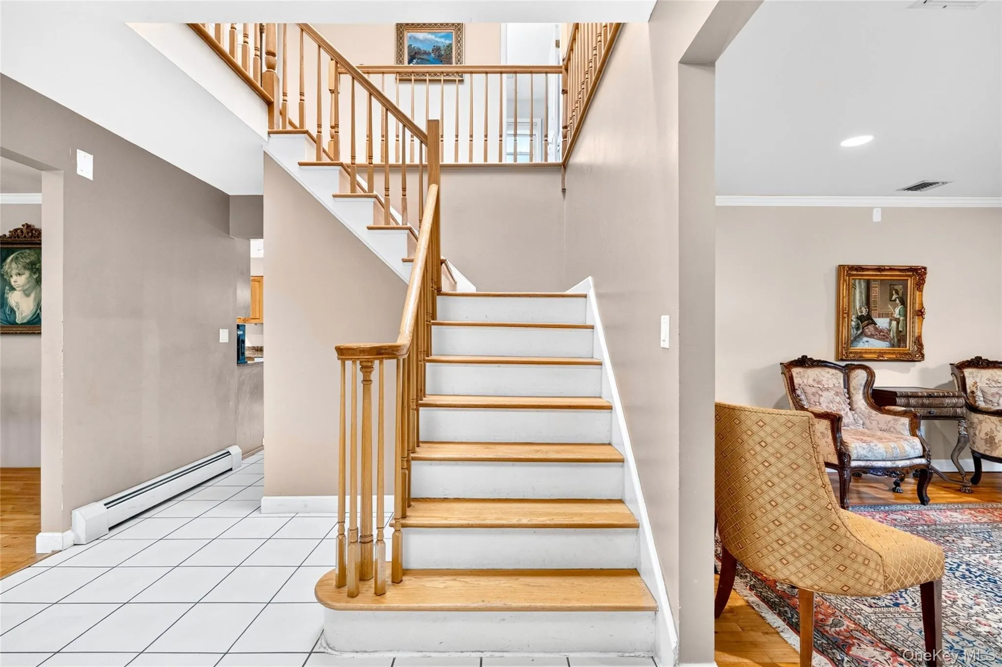 Hardwood staircase with natural wood balusters, white risers, and a curved bottom step Hardwood staircase with natural wood balusters, white risers, and a curved bottom step
