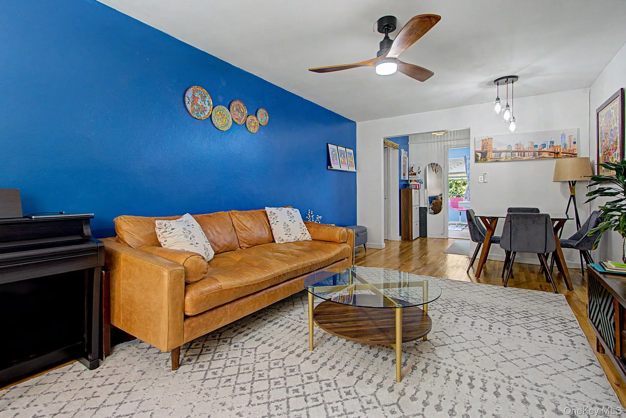 Living area featuring wood-finish flooring, a contemporary ceiling fan Living area featuring wood-finish flooring, a contemporary ceiling fan