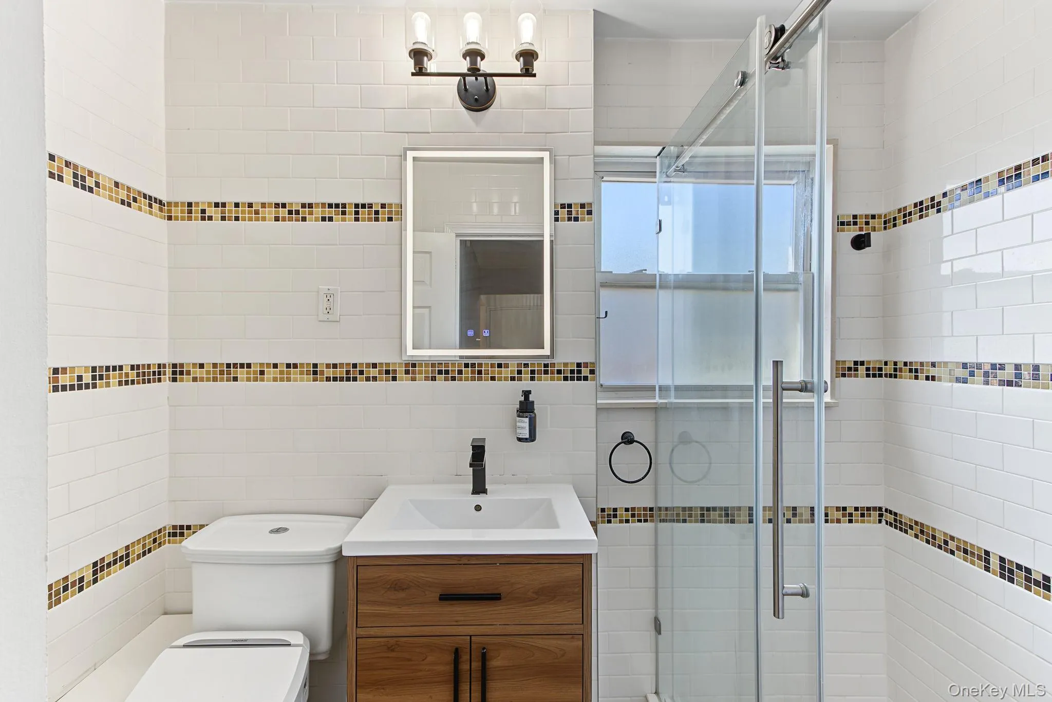 White subway tile walls with decorative mosaic tile bands White subway tile walls with decorative mosaic tile bands