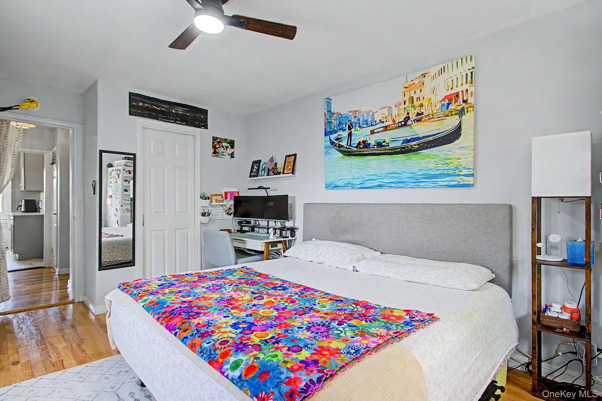 Bedroom featuring hardwood-finish flooring and a ceiling fan with integrated lighting Bedroom featuring hardwood-finish flooring and a ceiling fan with integrated lighting