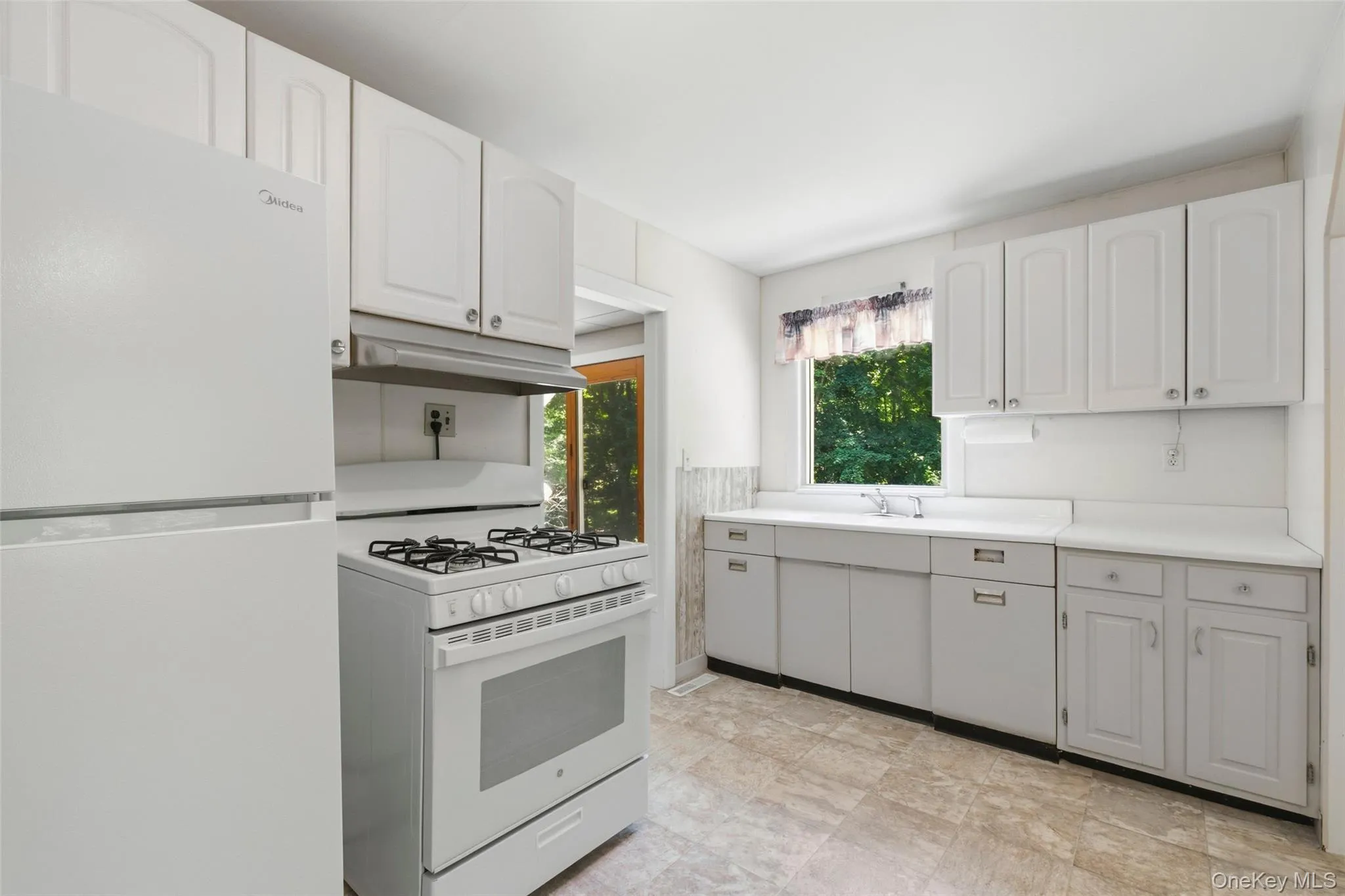 Kitchen featuring brand new appliances overlooking lovely front yard. Kitchen featuring brand new appliances overlooking lovely front yard.