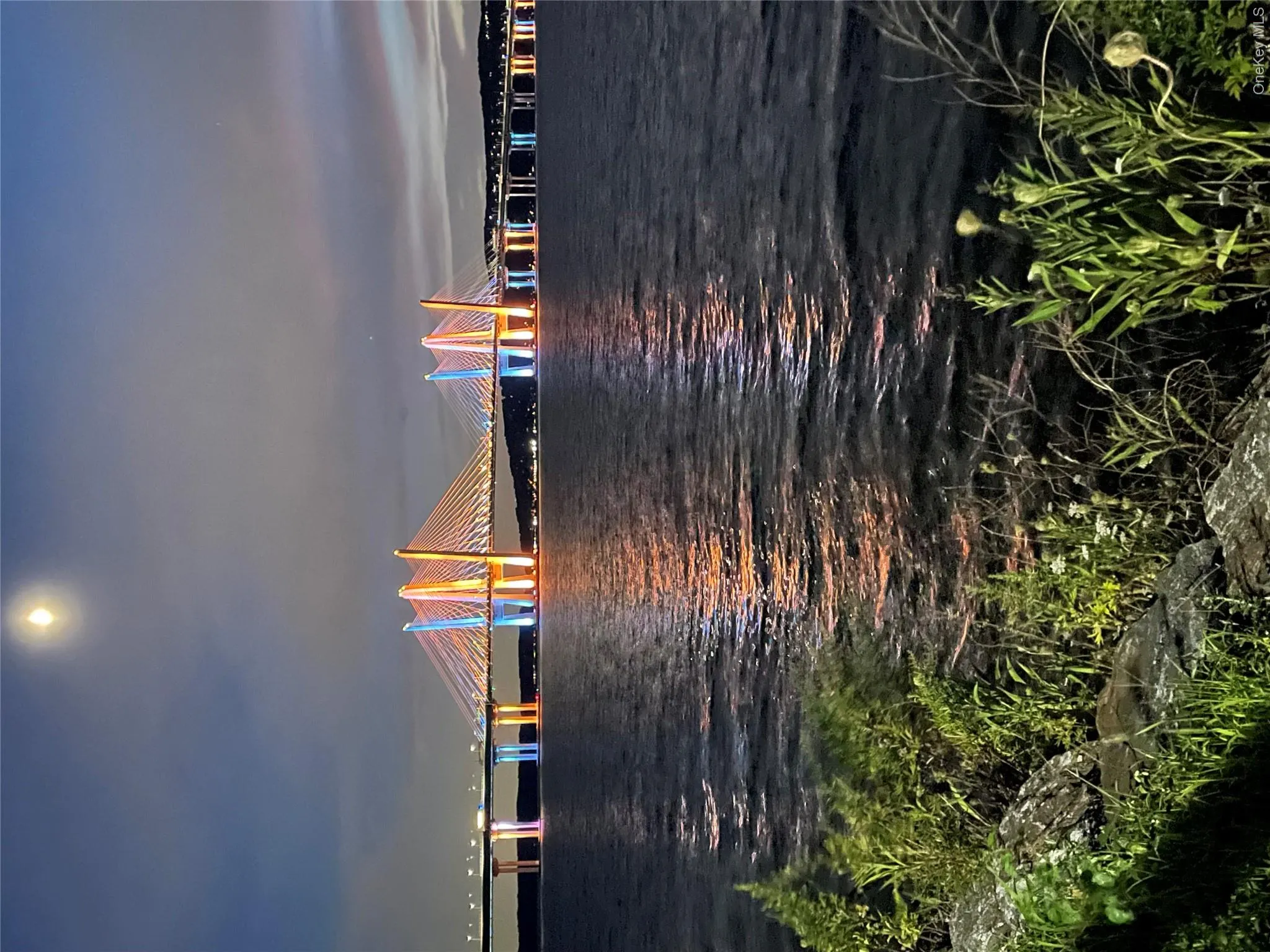 Stunning evening views of the illuminated bridge reflecting across the river Stunning evening views of the illuminated bridge reflecting across the river