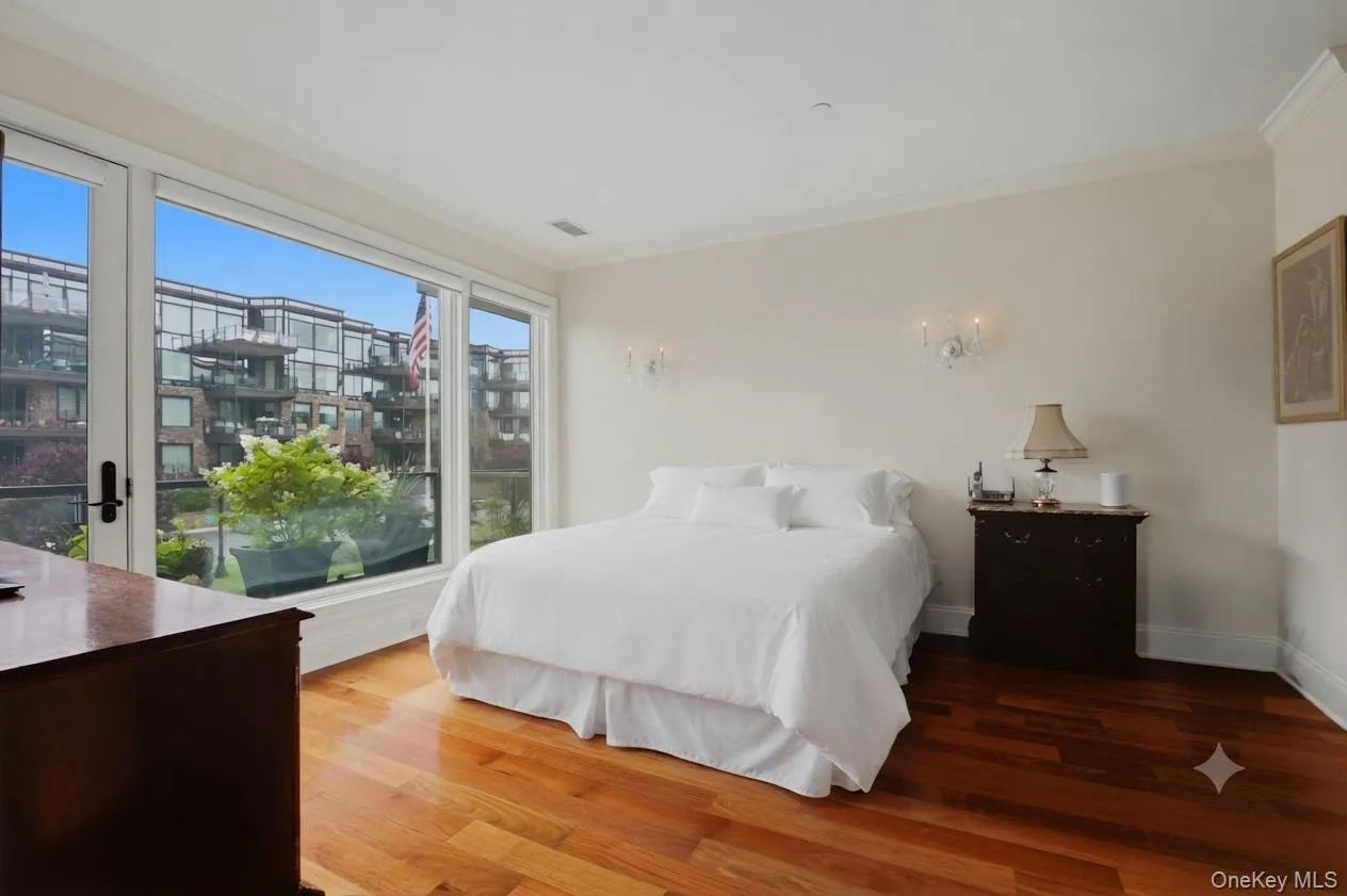 Alternate view of the primary suite showcasing private balcony access and views of the beautifully maintained community. (Bedding was virtually staged) Alternate view of the primary suite showcasing private balcony access and views of the beautifully maintained community. (Bedding was virtually staged)