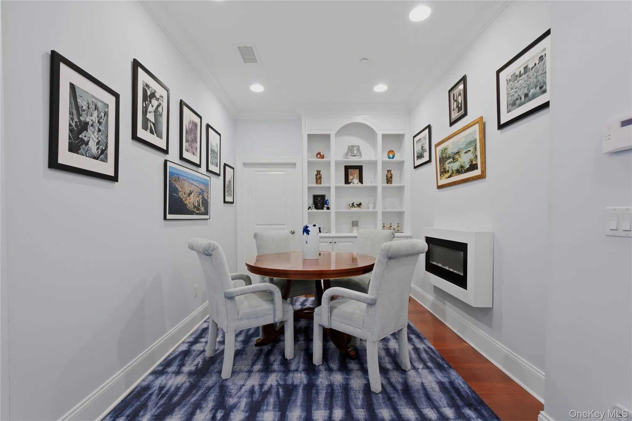 Versatile Den or Home Office with custom built-in shelving, currently utilized as a dining room Versatile Den or Home Office with custom built-in shelving, currently utilized as a dining room