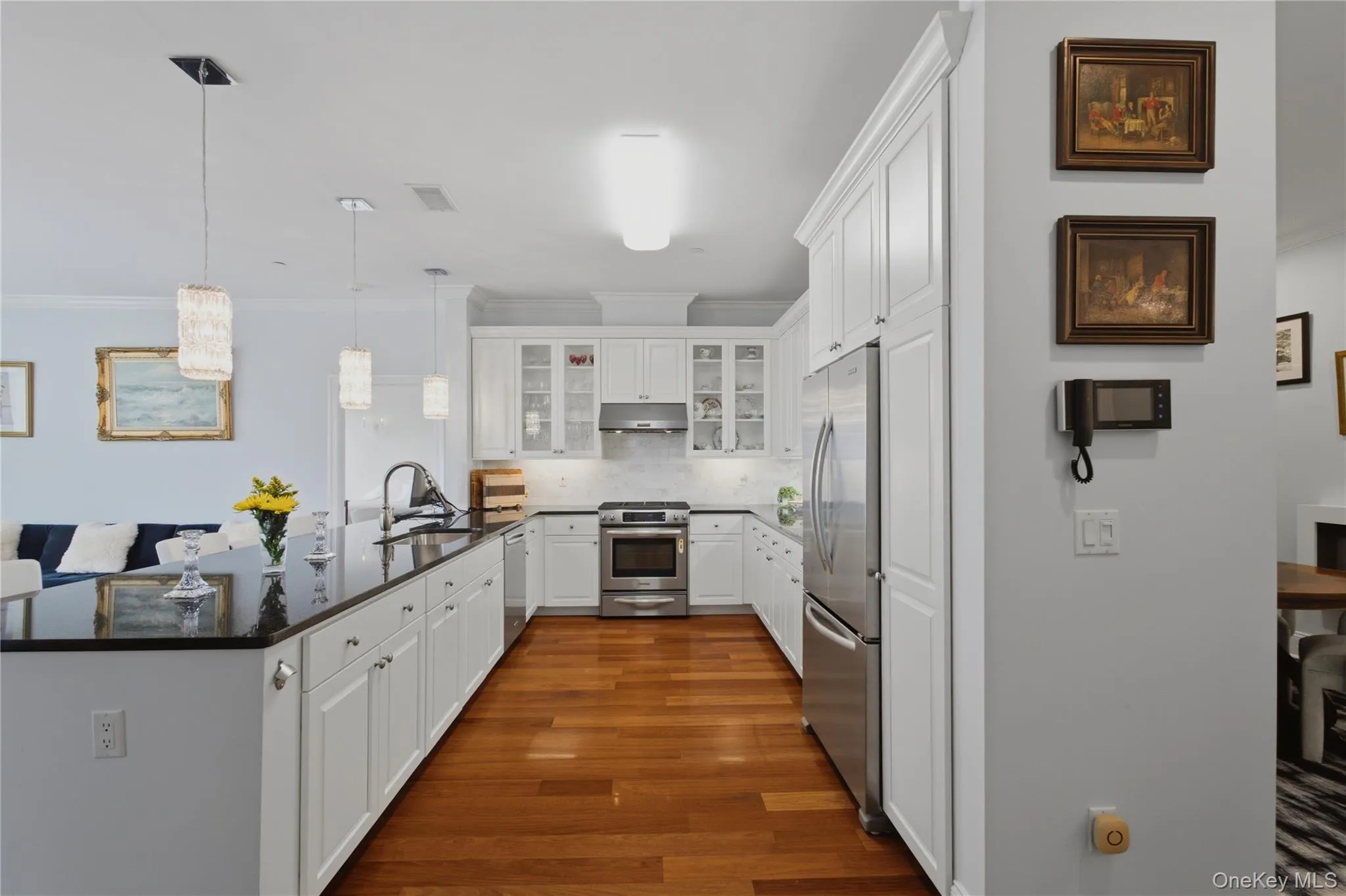 Stainless steel appliances, elegant pendant lighting, and an expansive counter create a stylish and functional kitchen. Stainless steel appliances, elegant pendant lighting, and an expansive counter create a stylish and functional kitchen.