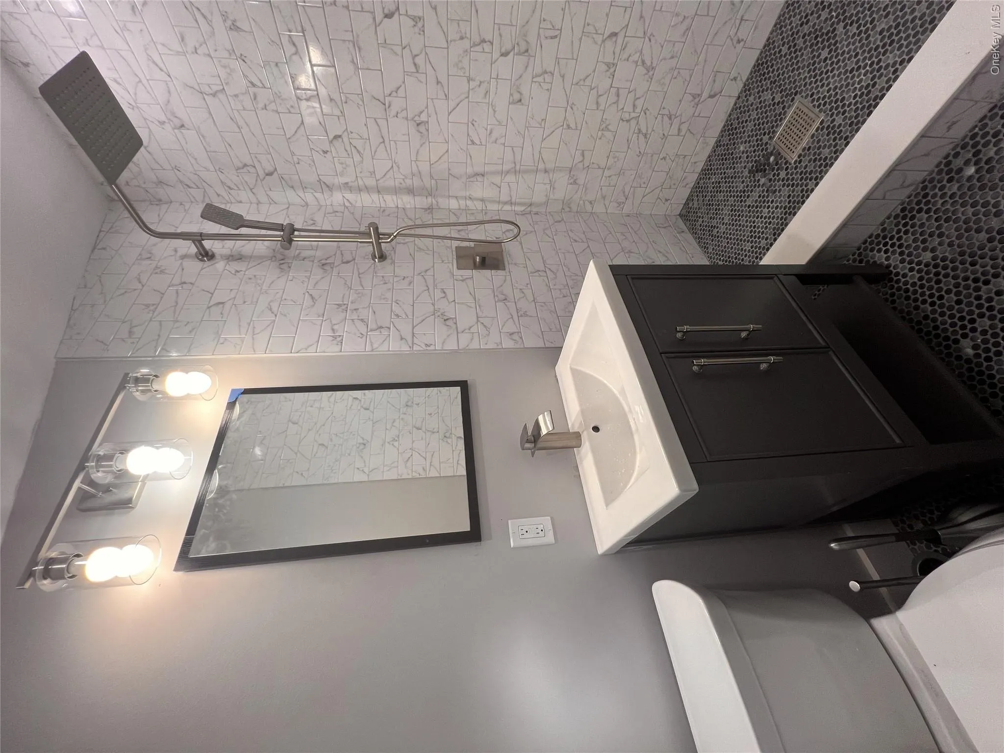 Bathroom with vanity, tiled shower, and tile patterned flooring Bathroom with vanity, tiled shower, and tile patterned flooring