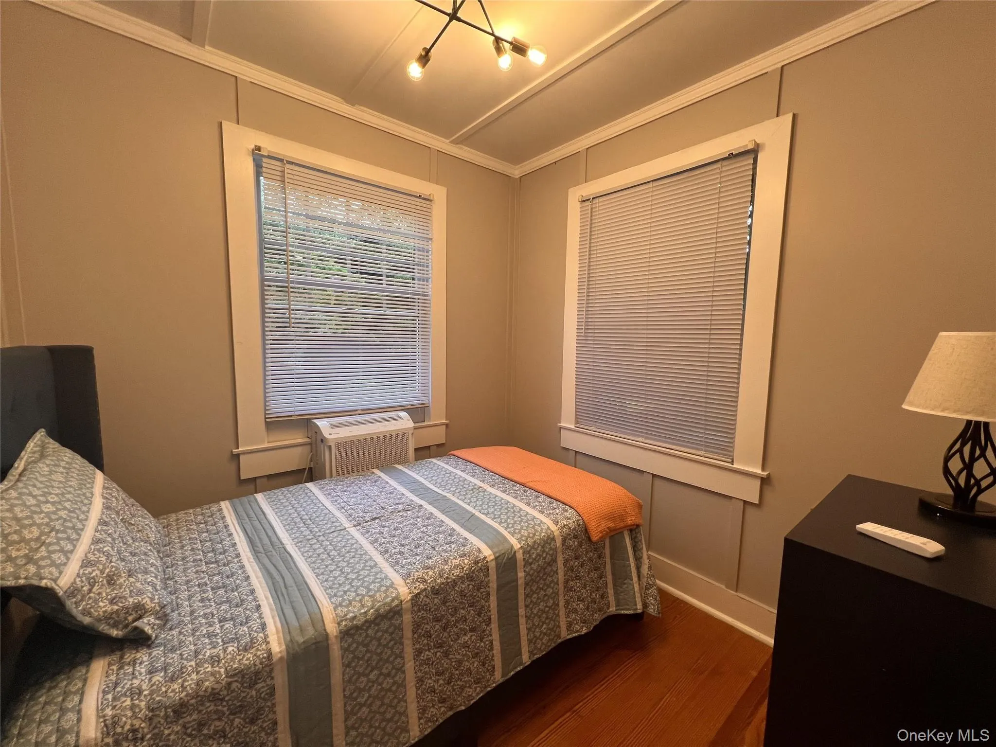 Bedroom with wood finished floors and ornamental molding Bedroom with wood finished floors and ornamental molding
