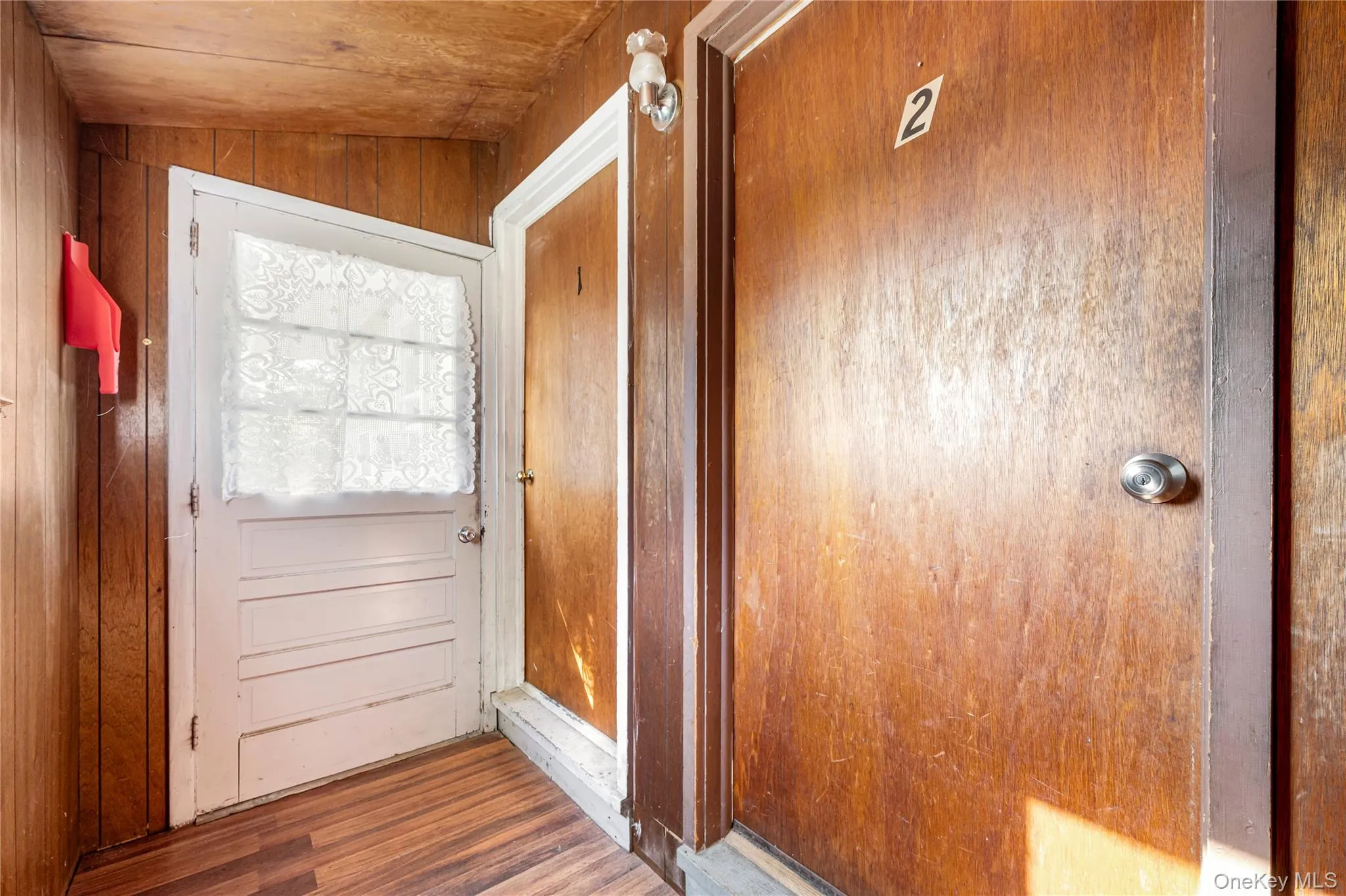 Doorway featuring dark wood-type flooring and wood walls Doorway featuring dark wood-type flooring and wood walls