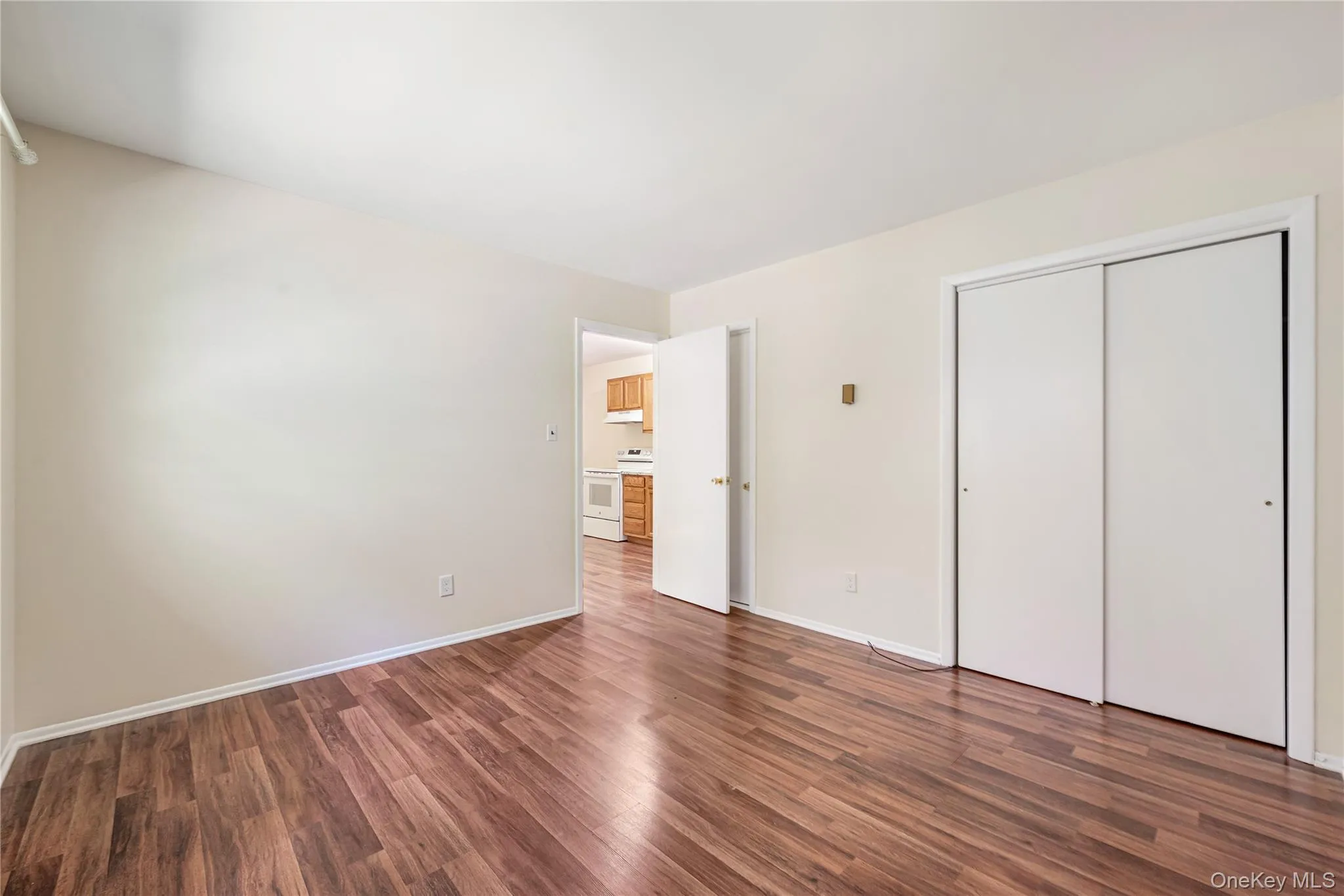 Unfurnished bedroom with dark hardwood / wood-style floors and a closet Unfurnished bedroom with dark hardwood / wood-style floors and a closet