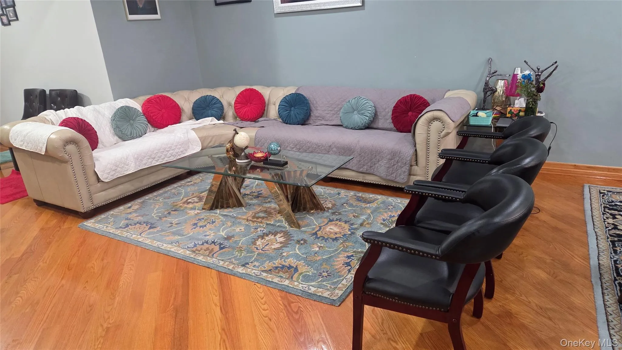 Hardwood flooring throughout a spacious living area featuring a large sectional sofa Hardwood flooring throughout a spacious living area featuring a large sectional sofa