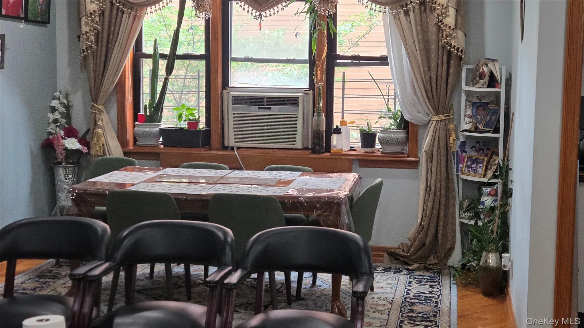 Dining area featuring a bay window with wood trim, decorative window treatments, and hard surface flooring Dining area featuring a bay window with wood trim, decorative window treatments, and hard surface flooring