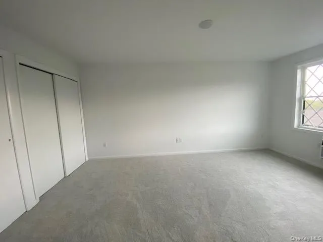 Unfurnished bedroom with carpet flooring and baseboards Unfurnished bedroom with carpet flooring and baseboards