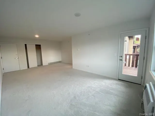 Empty room featuring light carpet, a baseboard heating unit, and recessed lighting Empty room featuring light carpet, a baseboard heating unit, and recessed lighting