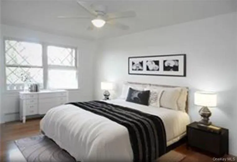 Bedroom with dark wood-style flooring and a ceiling fan Bedroom with dark wood-style flooring and a ceiling fan