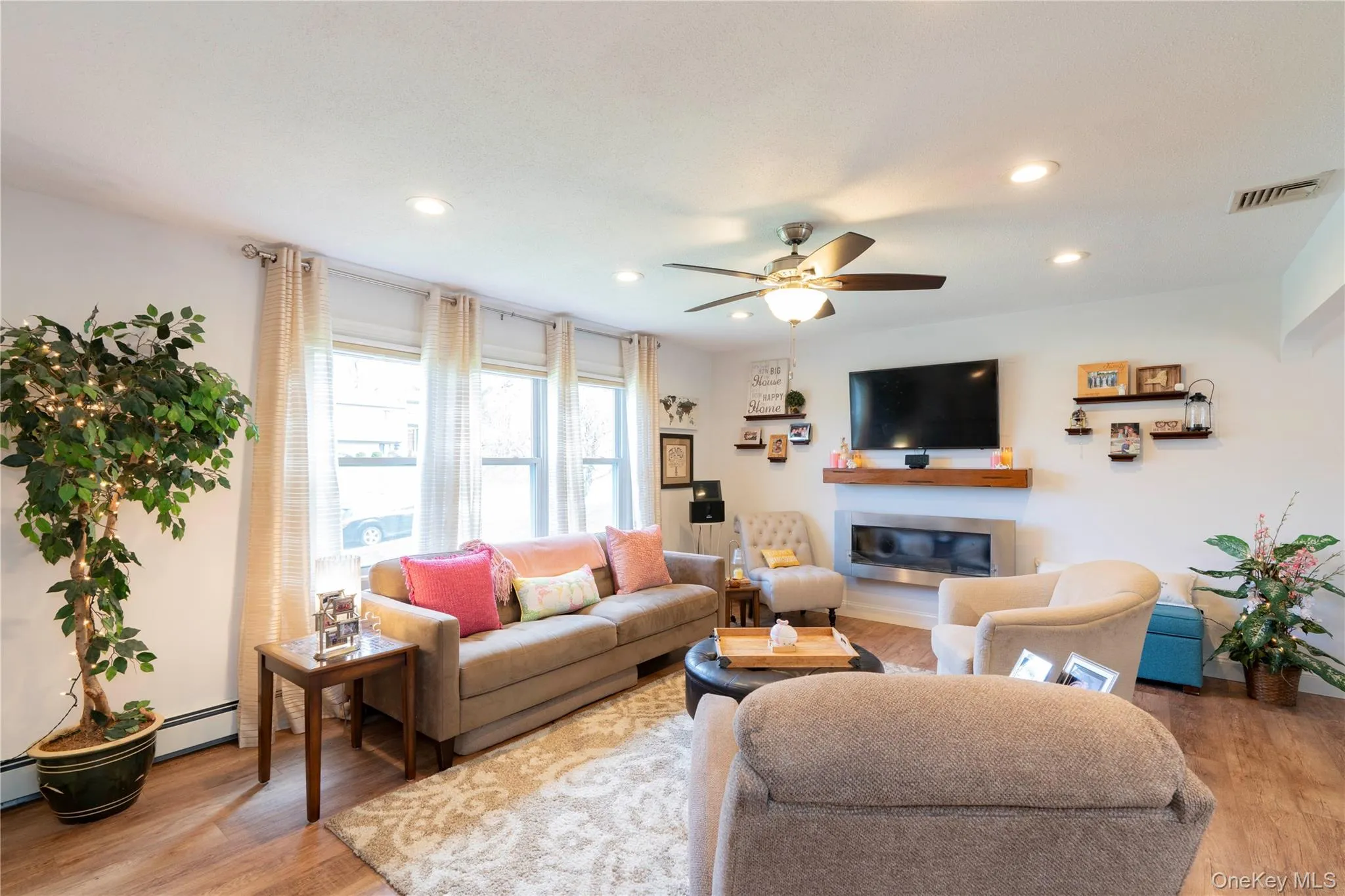 Spacious Living area with light wood flooring, ceiling fan and recessed lighting Spacious Living area with light wood flooring, ceiling fan and recessed lighting