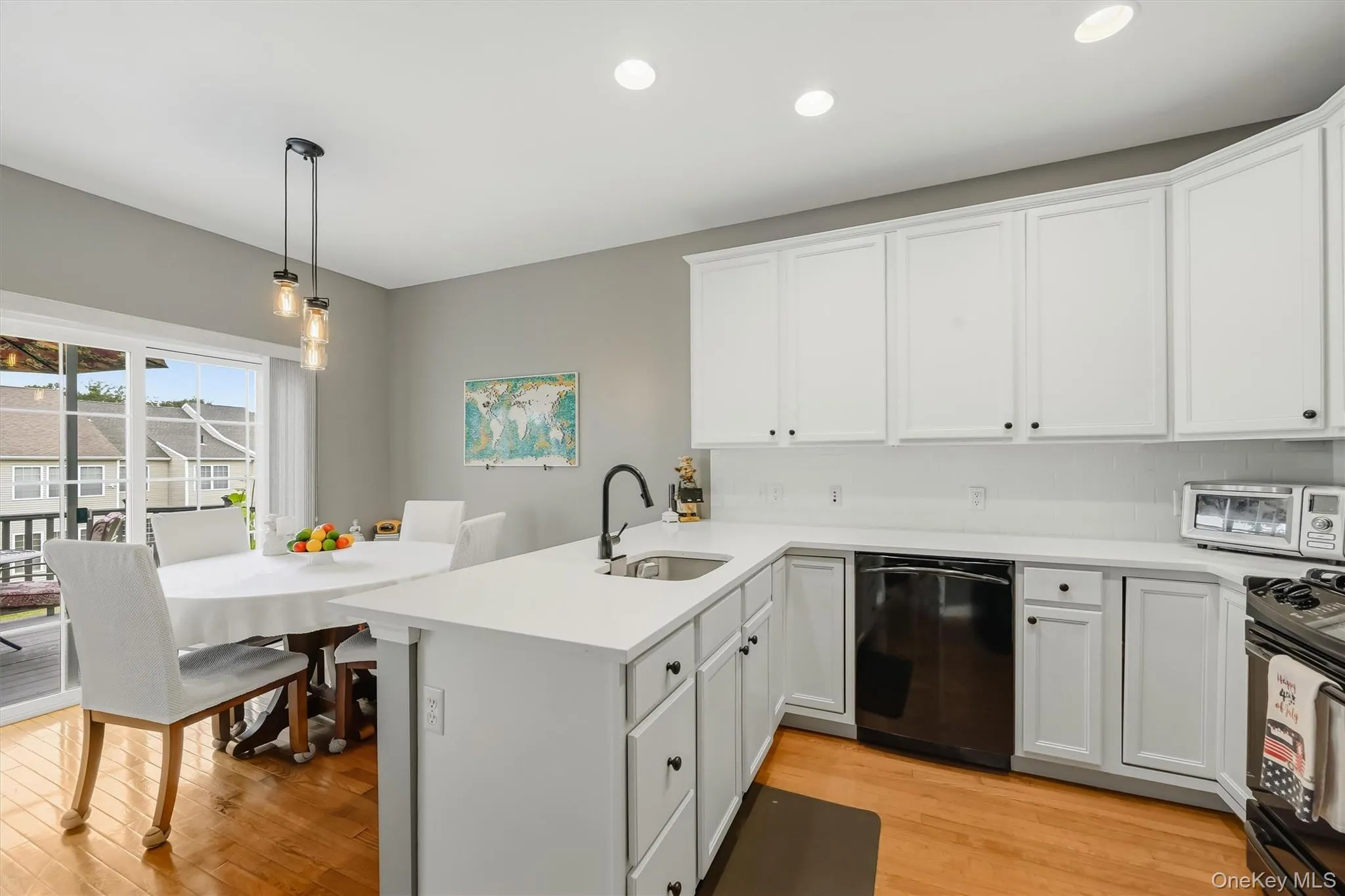 The kitchen is bright with both recessed and pendant lighting. The kitchen is bright with both recessed and pendant lighting.