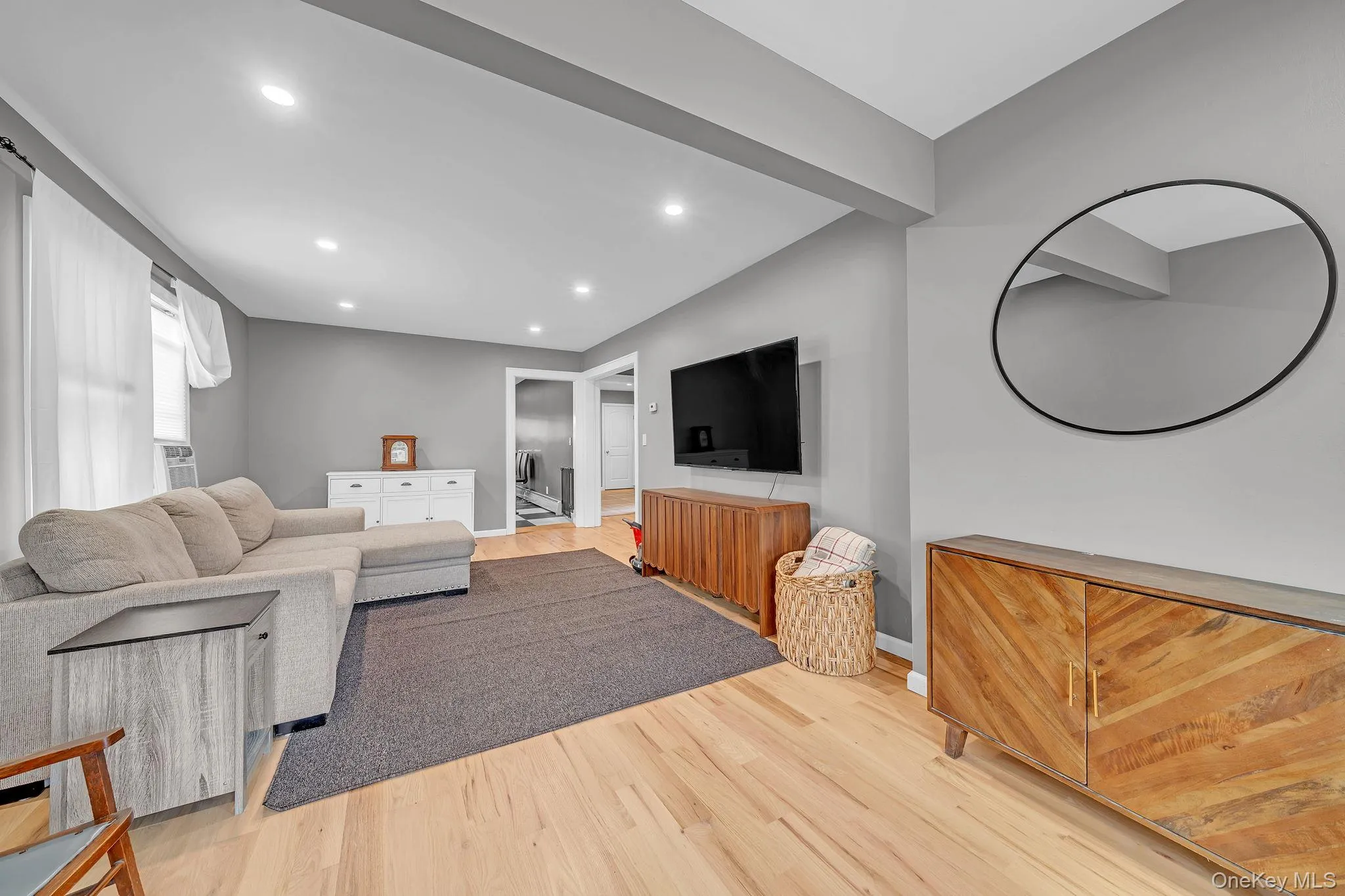 Living area featuring light wood-finish flooring, recessed lighting, and neutral wall tones Living area featuring light wood-finish flooring, recessed lighting, and neutral wall tones