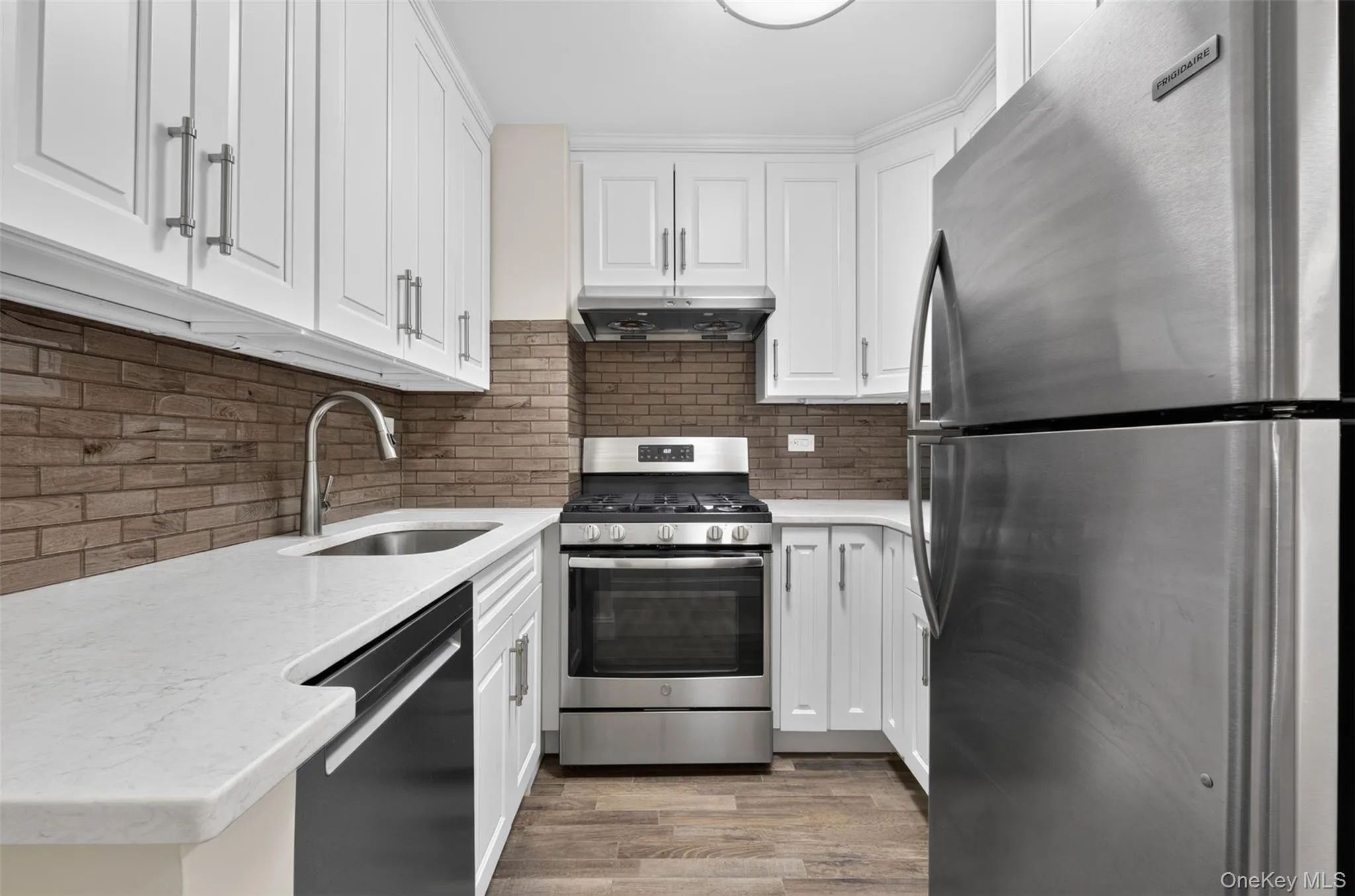 Updated kitchen with stainless steel appliances, including a gas range, exhaust range hood, full size dishwasher, stone counters, and modern hardware. Updated kitchen with stainless steel appliances, including a gas range, exhaust range hood, full size dishwasher, stone counters, and modern hardware.
