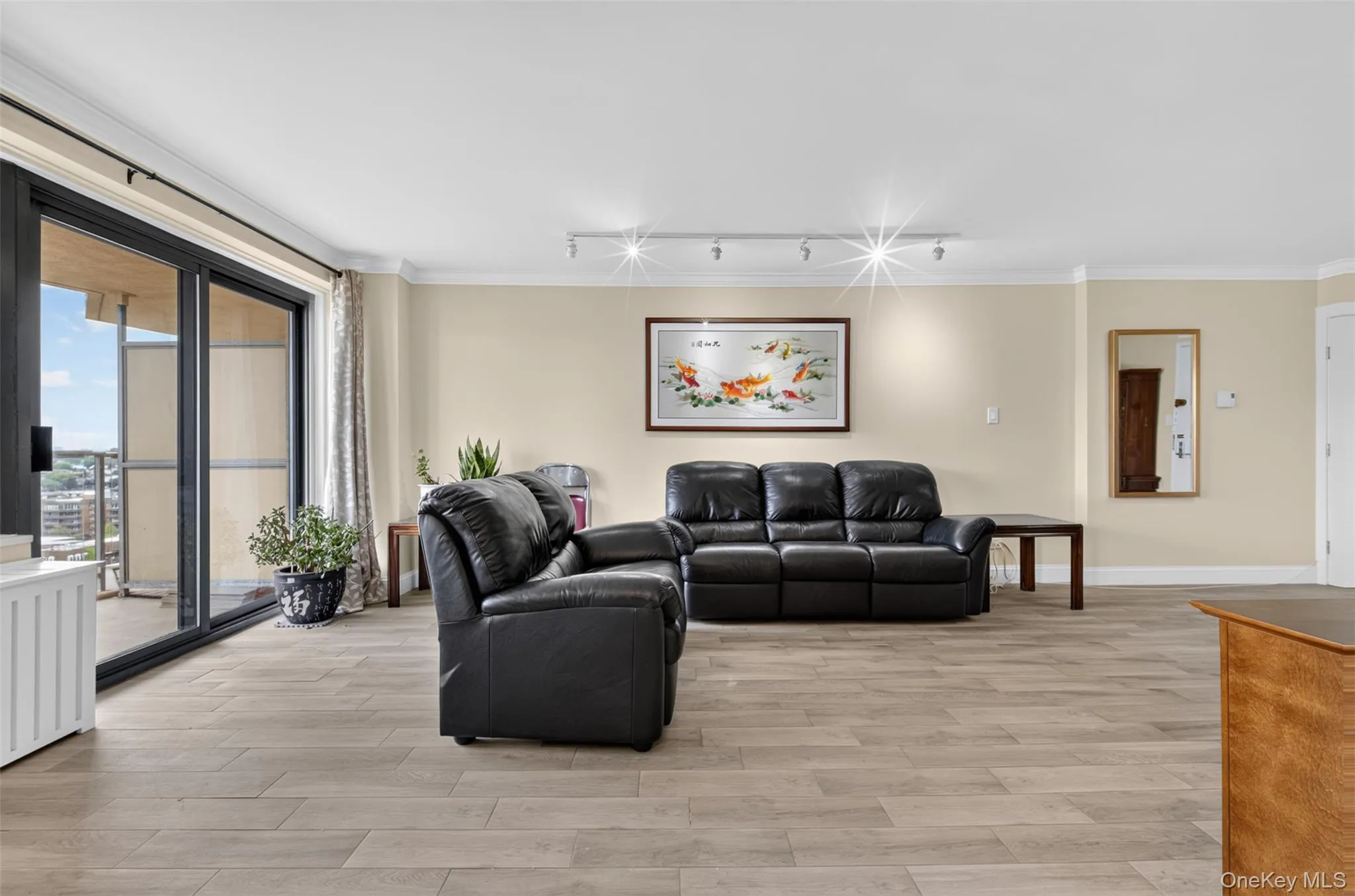 Living room with sliding glass doors opening to the expansive covered balcony, creating a bright, airy space with easy indoor-outdoor flow. Living room with sliding glass doors opening to the expansive covered balcony, creating a bright, airy space with easy indoor-outdoor flow.