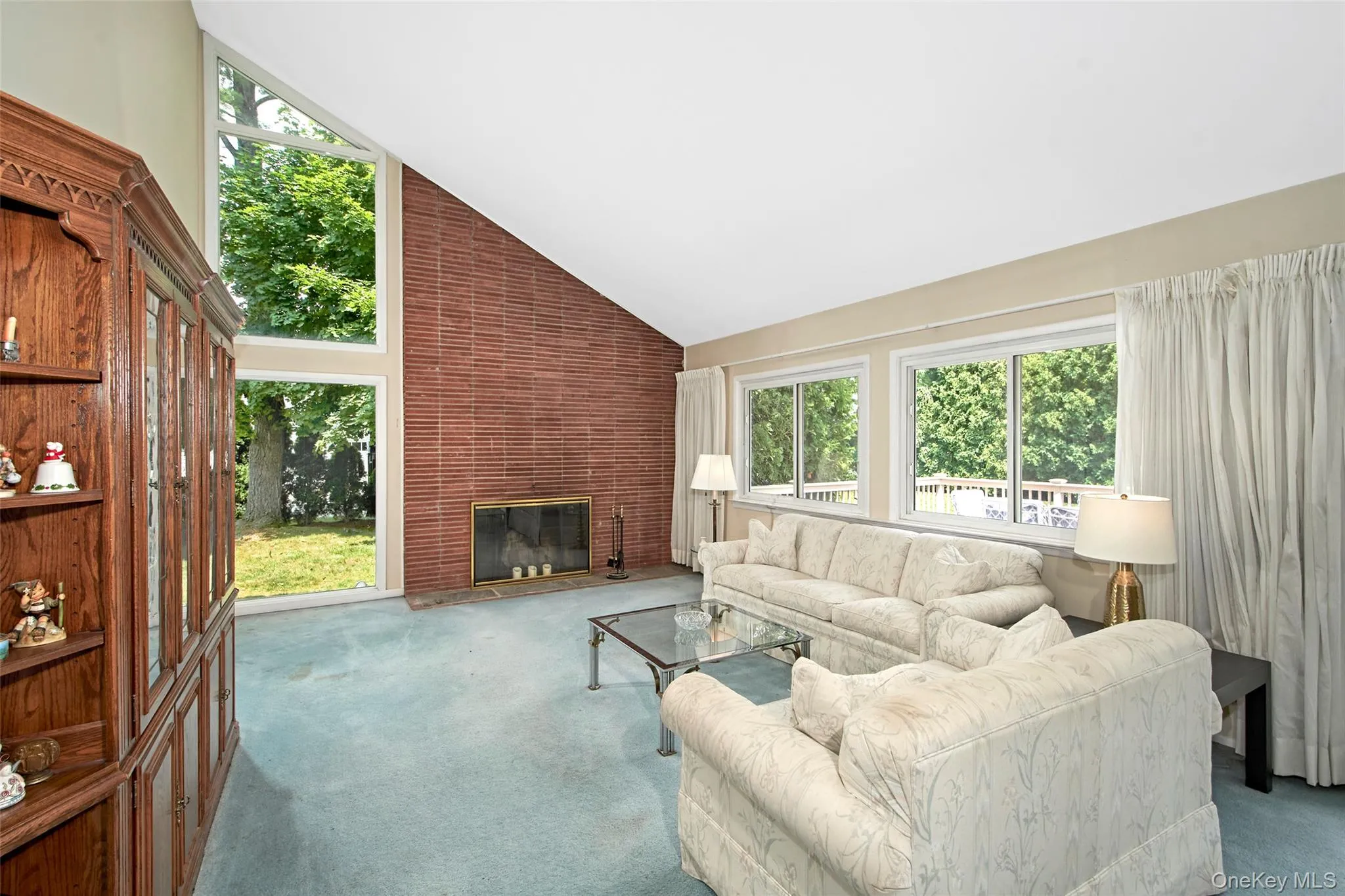 Expansive open concept space with vaulted ceiling, floor to ceiling window and wood burning fireplace Expansive open concept space with vaulted ceiling, floor to ceiling window and wood burning fireplace