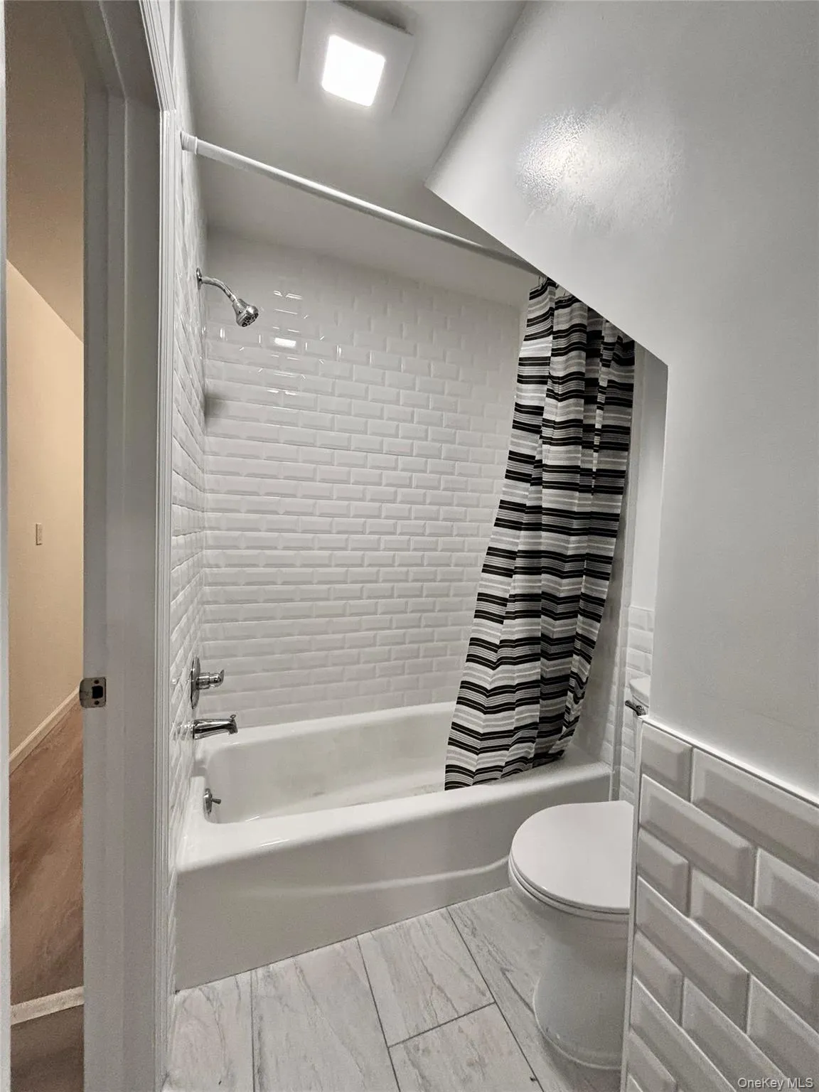 Full bathroom featuring shower / bath combo and toilet Full bathroom featuring shower / bath combo and toilet