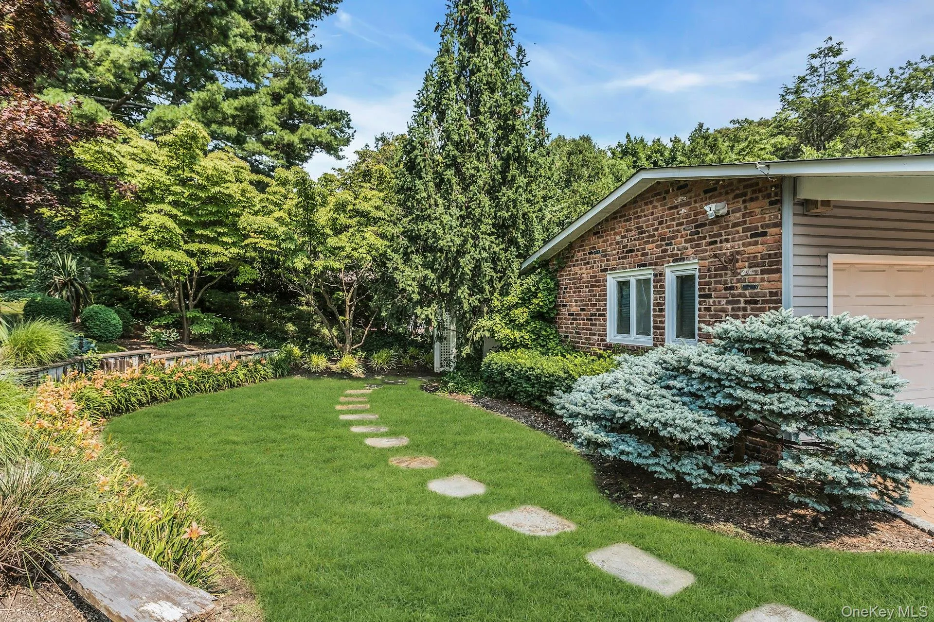 Manicured lawn with stepping stone pathway and diverse landscaping Manicured lawn with stepping stone pathway and diverse landscaping