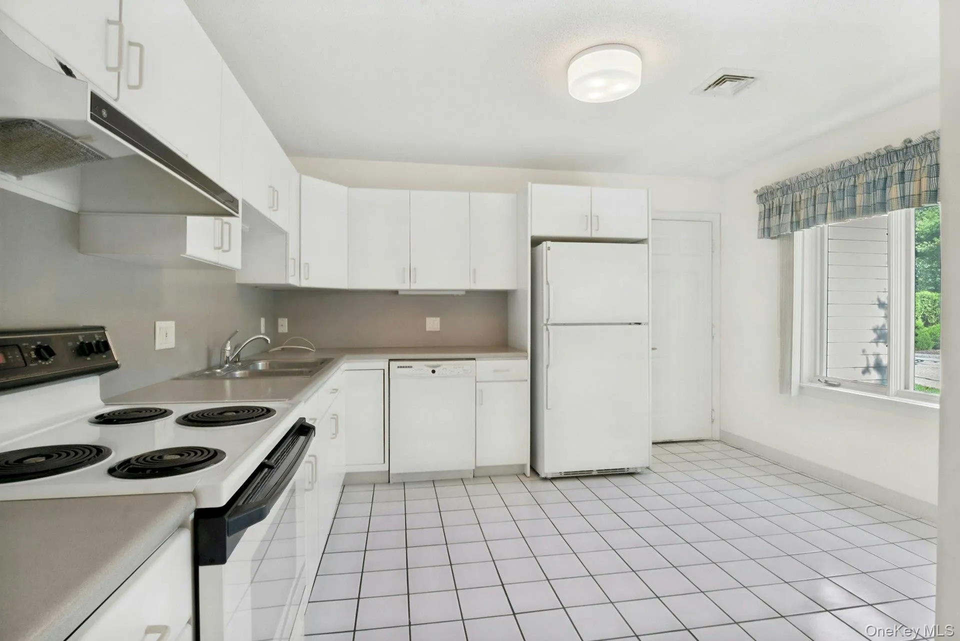 Tiled kitchen floor with window overlooking the front and door to garage.. Tiled kitchen floor with window overlooking the front and door to garage..