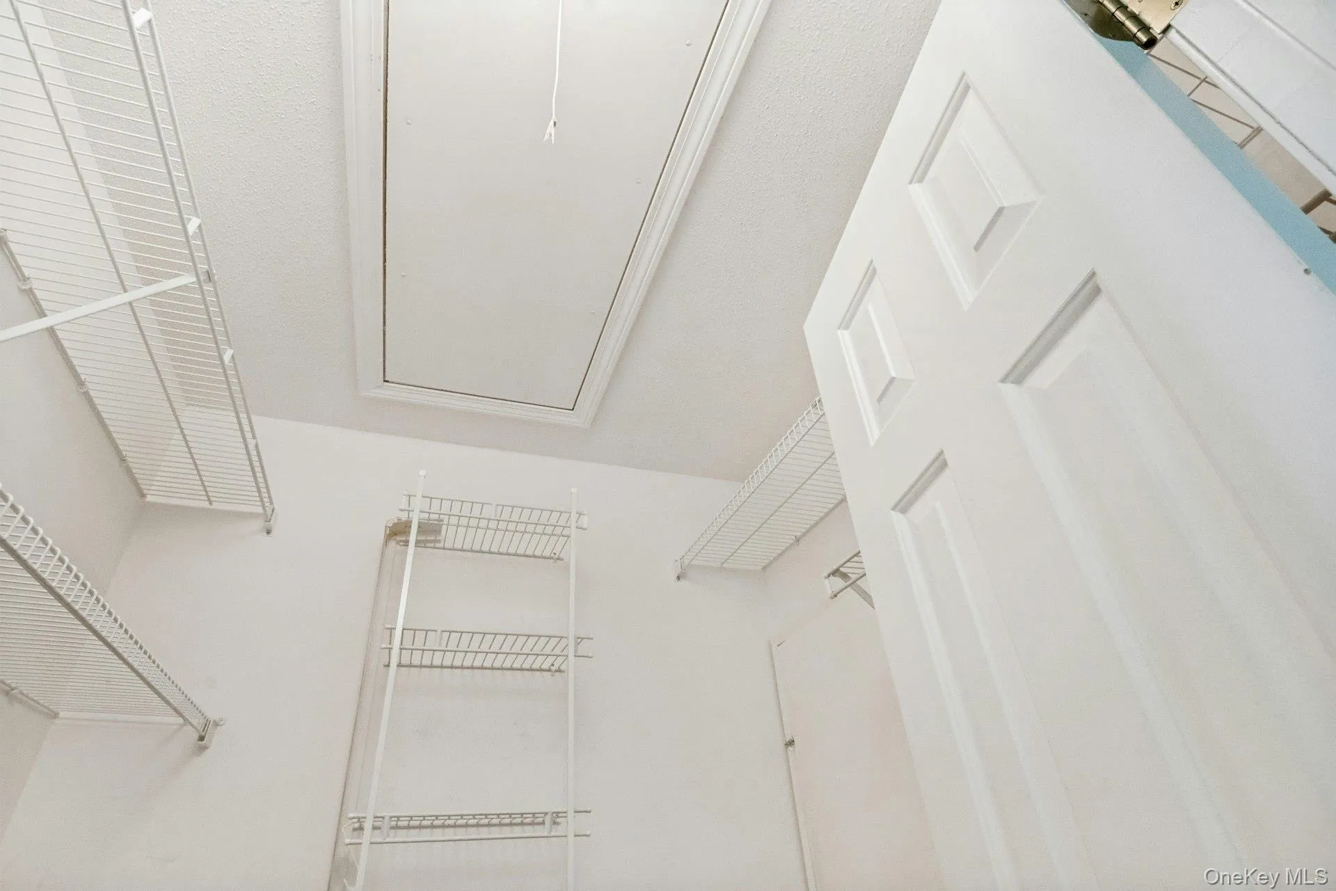 Walk-in closet in the primary bedroom w shelving & access to attic & hot water heater Walk-in closet in the primary bedroom w shelving & access to attic & hot water heater