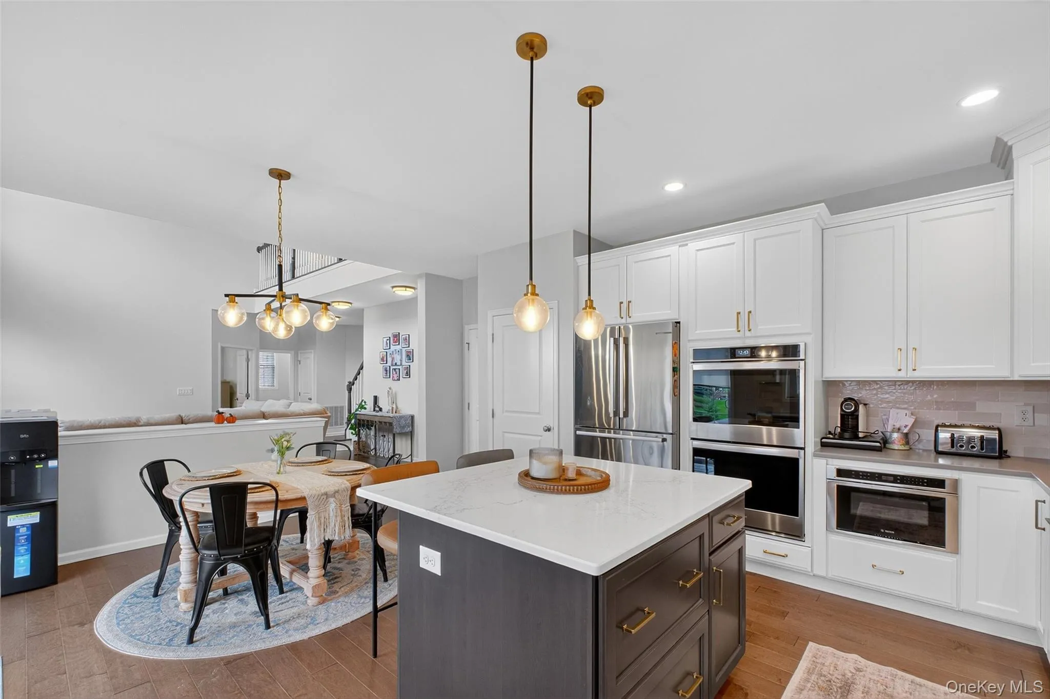 Kitchen with white cabinetry, decorative light fixtures, appliances with stainless steel finishes, and recessed lighting Kitchen with white cabinetry, decorative light fixtures, appliances with stainless steel finishes, and recessed lighting