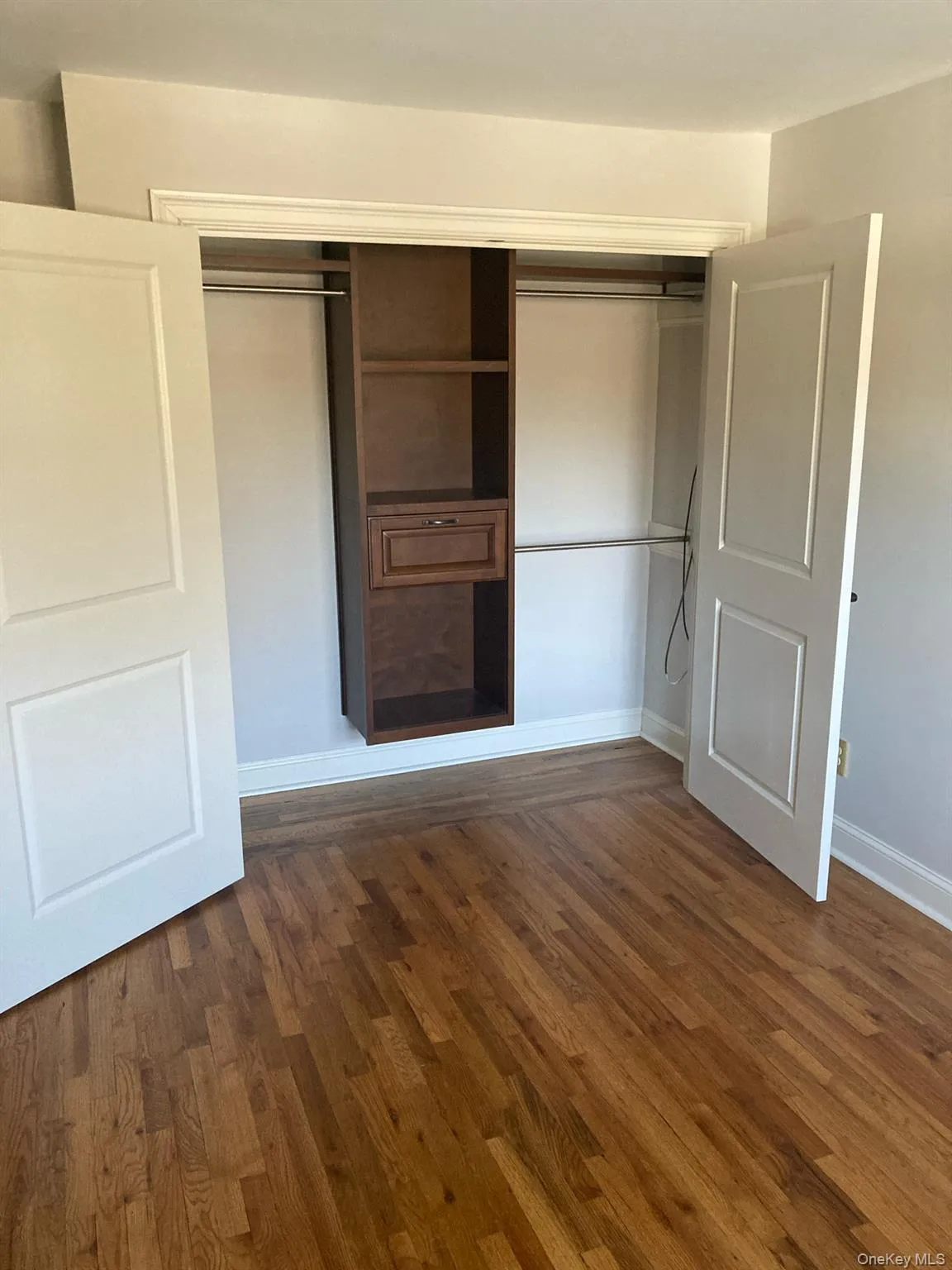 Unfurnished bedroom featuring a closet and dark wood finished floors Unfurnished bedroom featuring a closet and dark wood finished floors