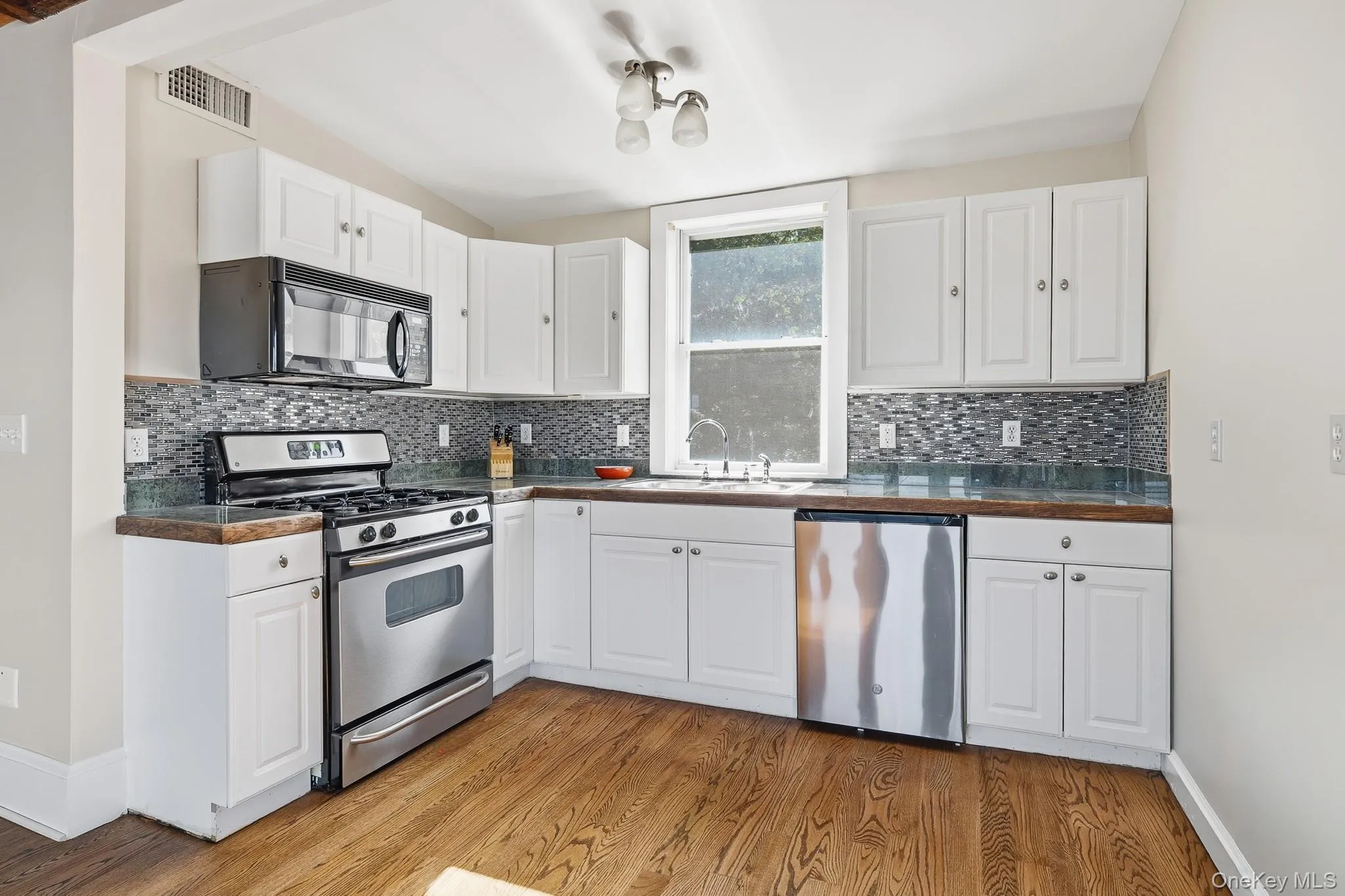 Updated, bright white kitchen with picture window features stainless steel appliances. (Remodeling will be complete in August). Updated, bright white kitchen with picture window features stainless steel appliances. (Remodeling will be complete in August).
